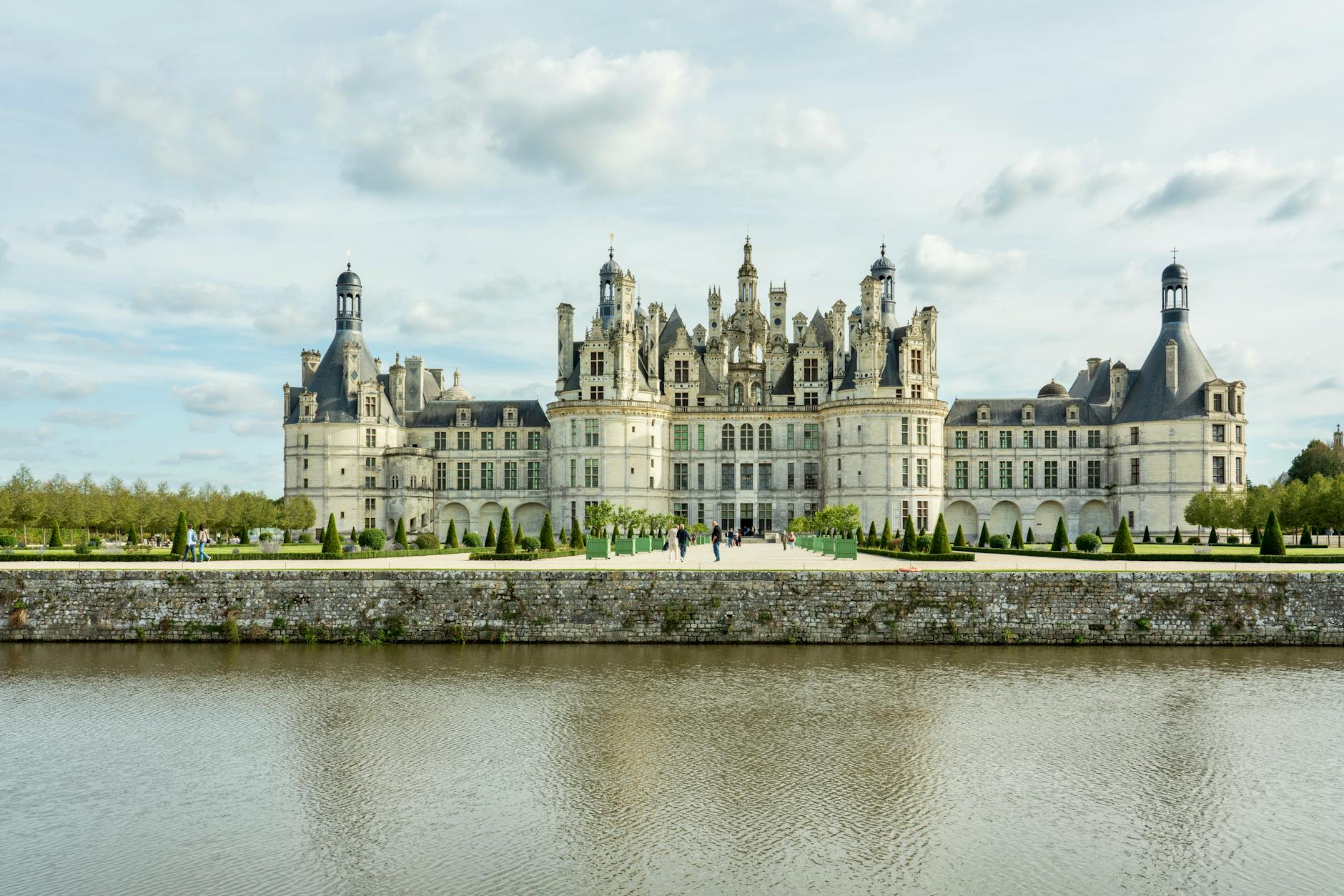 Château de Chambord reflecting in water under bright sky