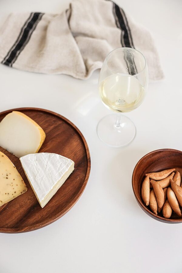 Cheese platter paired with white wine on a table