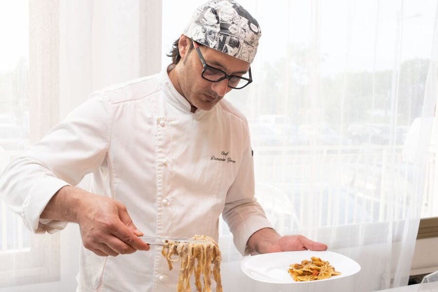 Chef serving fresh pasta on a plate