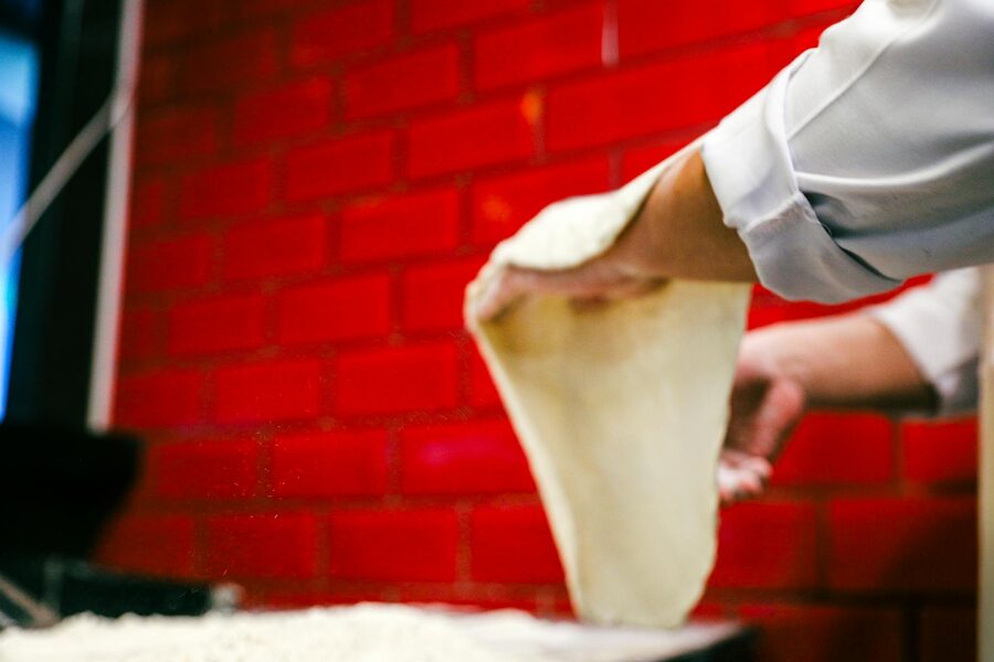 Chef stretching pizza dough skillfully
