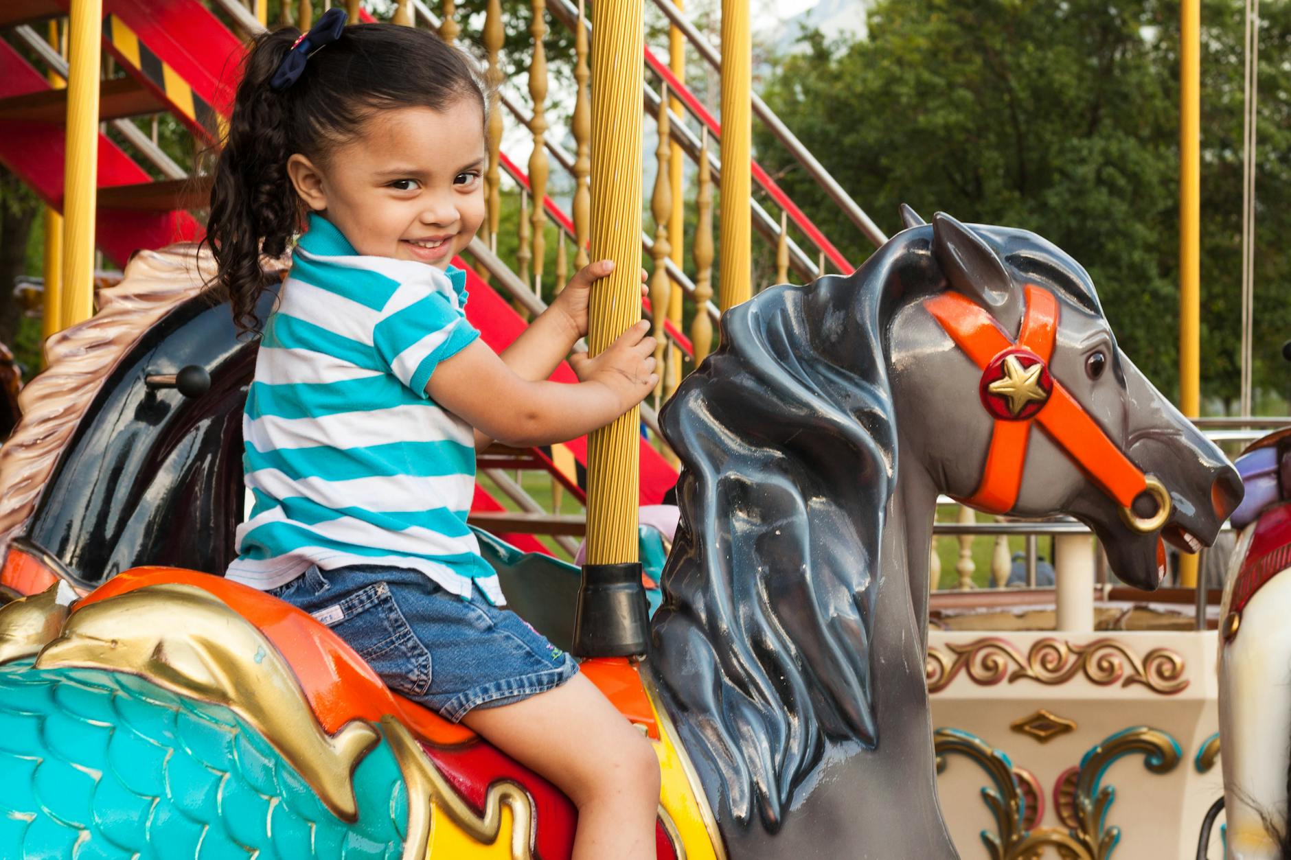 Child enjoying a carousel ride at an amusement park