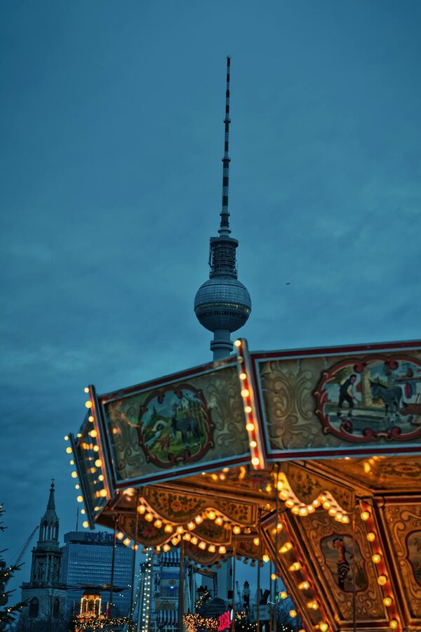 Christmas carousel near Berlin TV Tower at dusk