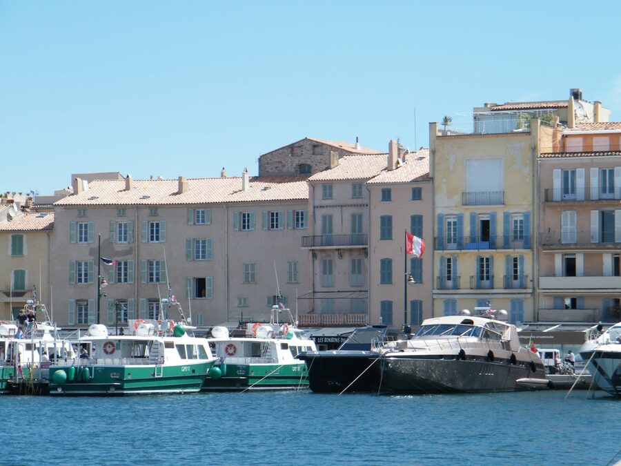 Motor yachts moored by modern buildings on the coast