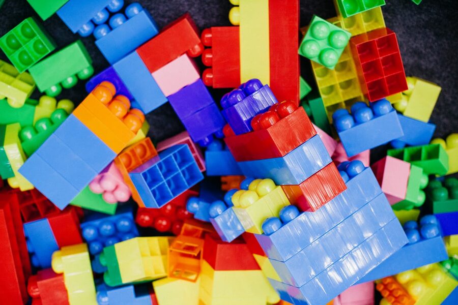 Brightly coloured plastic LEGO building blocks arranged in a playful pattern