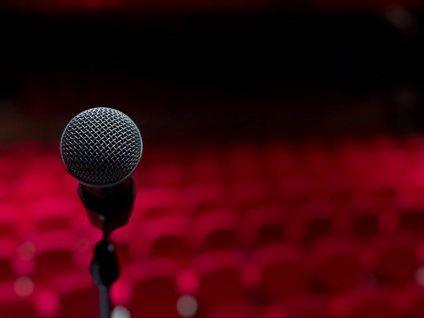 Close-up of microphone with empty red theatre seats