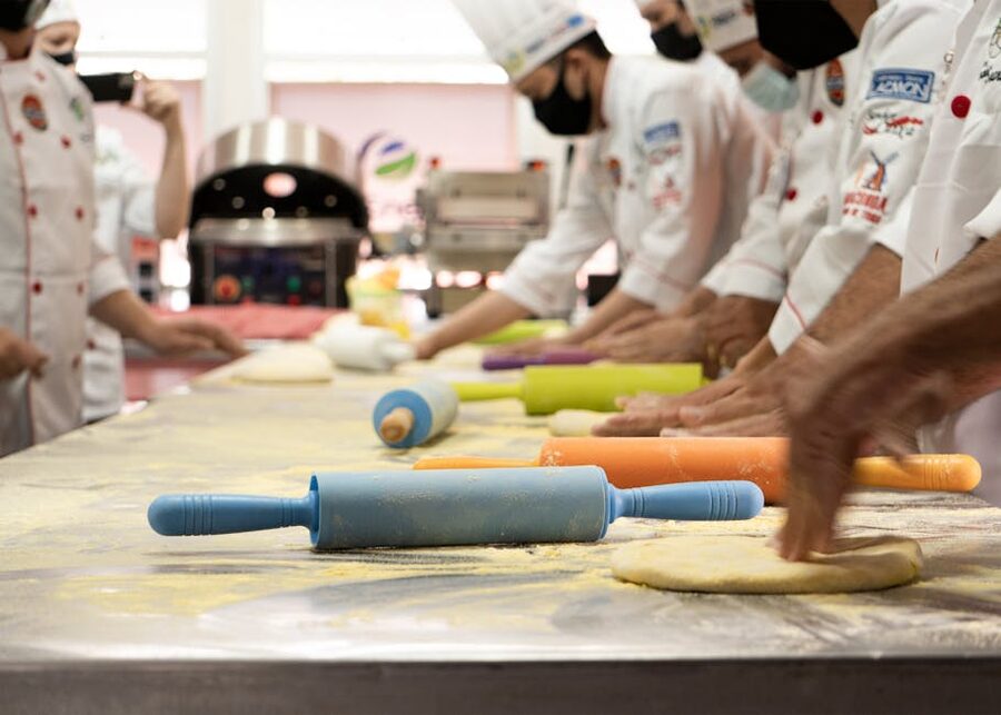 Cooking class students with rolling pins and dough