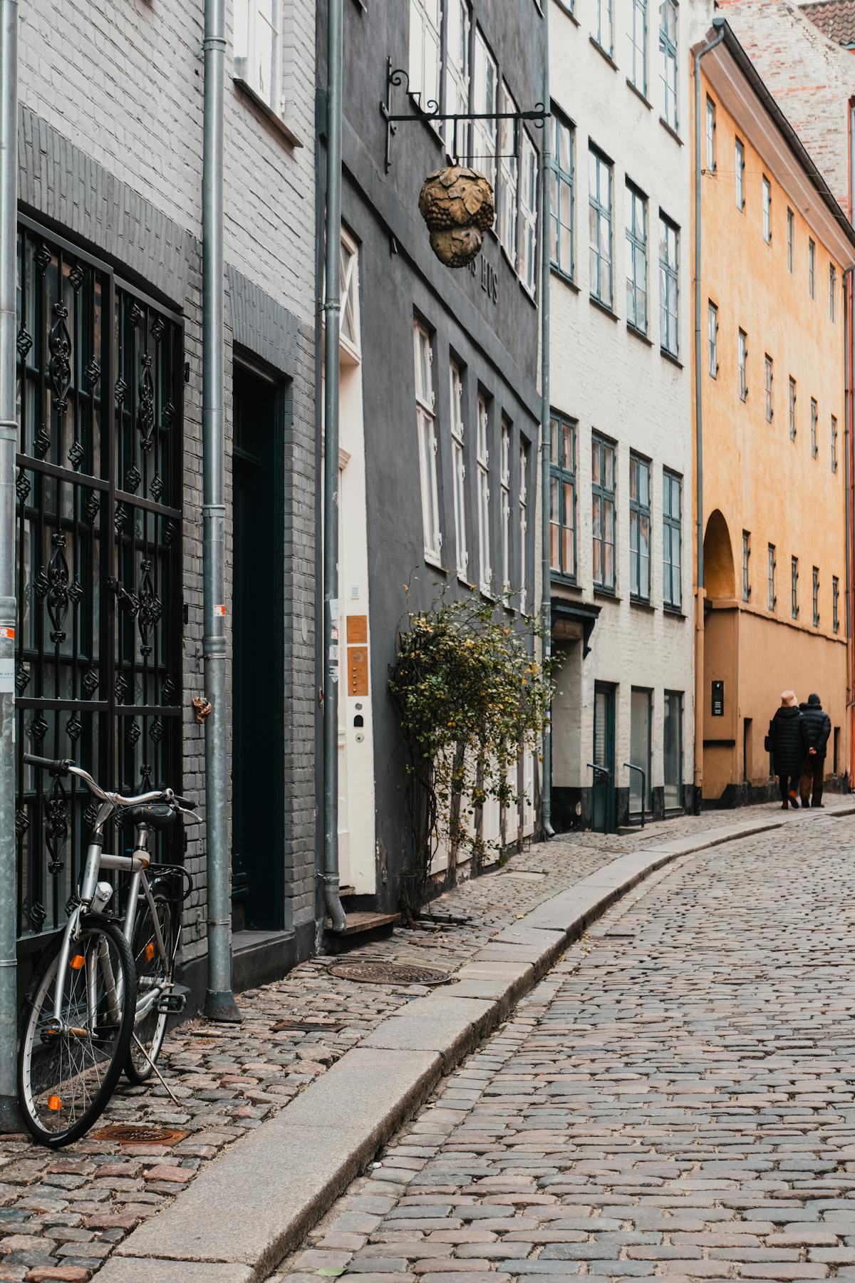 Quaint cobblestone street in Copenhagen with bicycles and colourful historic buildings