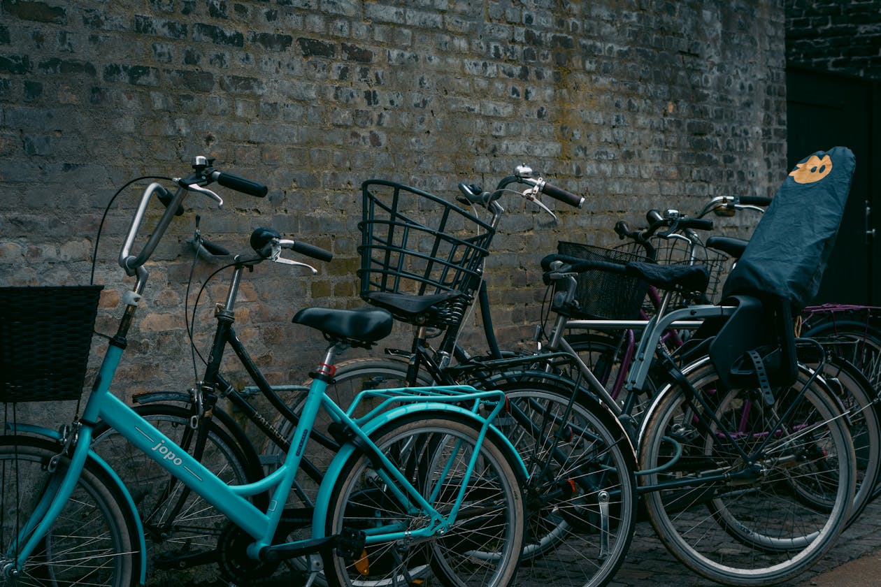 Row of colourful bicycles parked beside a brick wall in urban Copenhagen Denmark