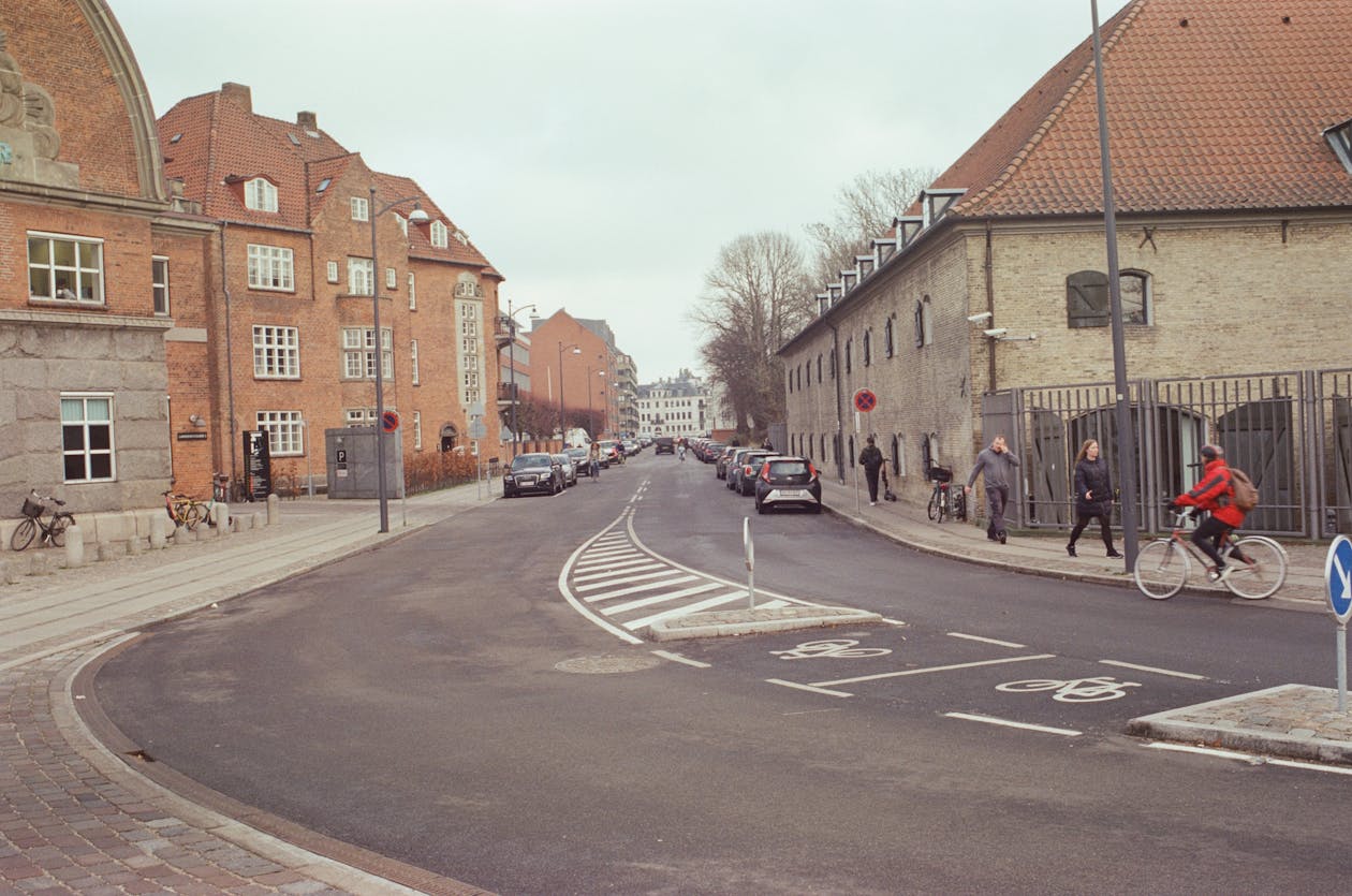 Charming street scene in Copenhagen with cyclists passing historic buildings