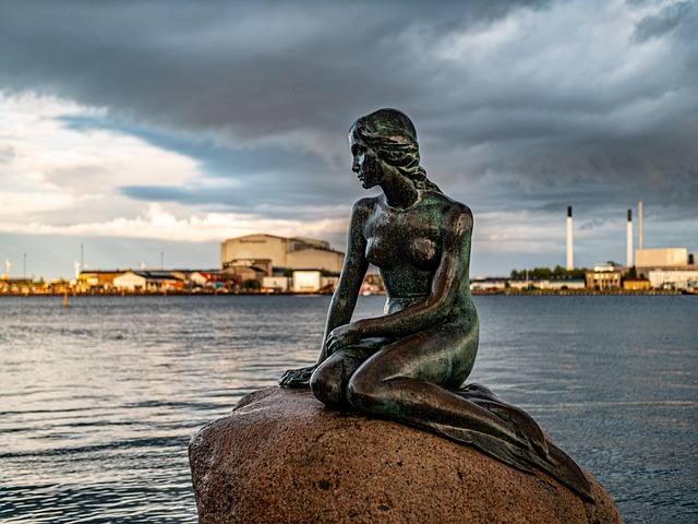 The Little Mermaid bronze statue sitting on a rock in Copenhagen harbour