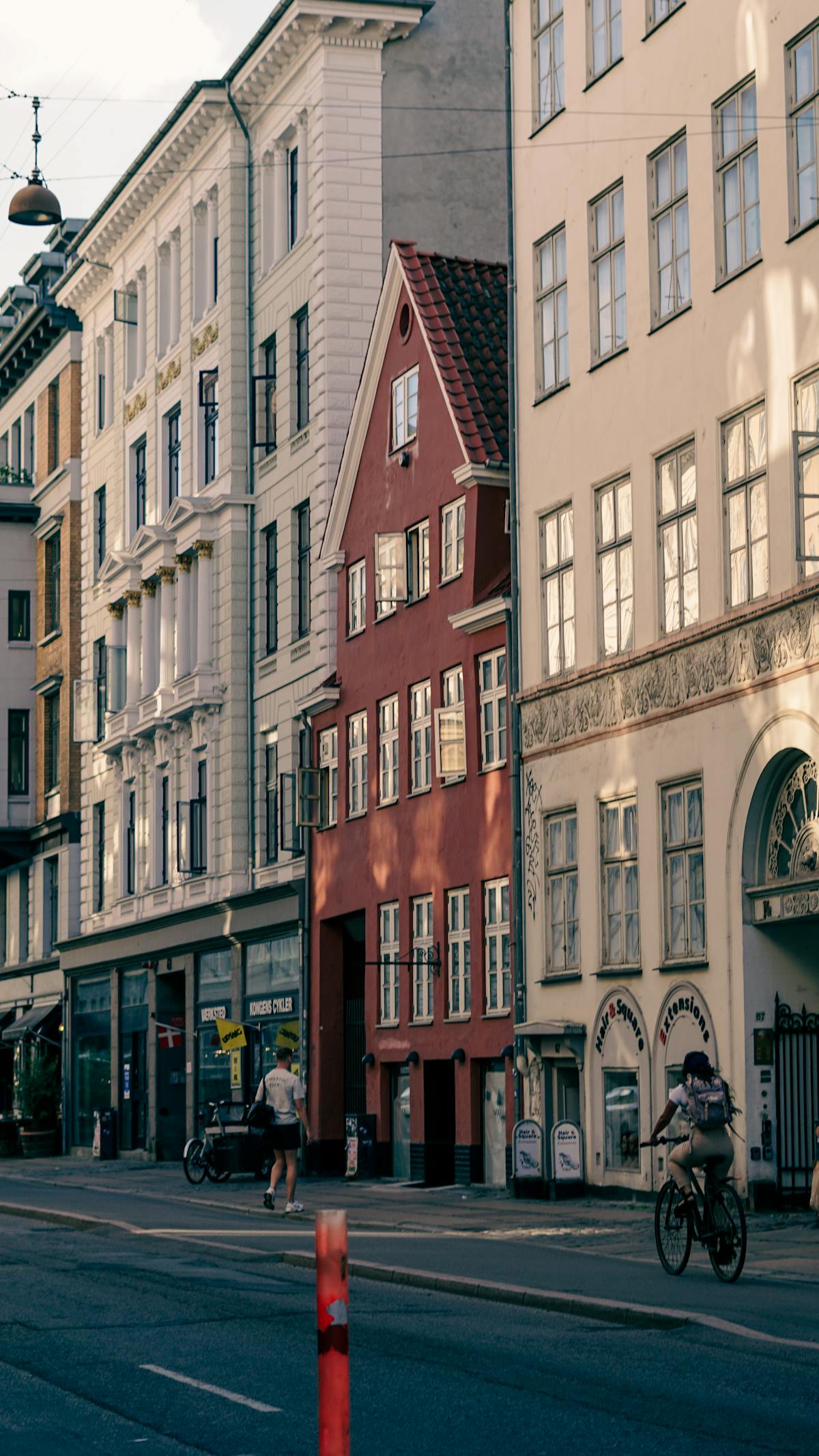 Cyclist passing neoclassical building facades in Copenhagen