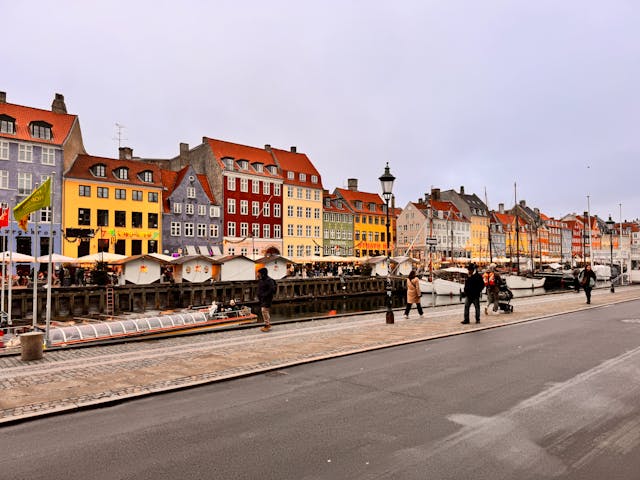 Busy street scene along the Nyhavn waterfront in Copenhagen with colourful buildings