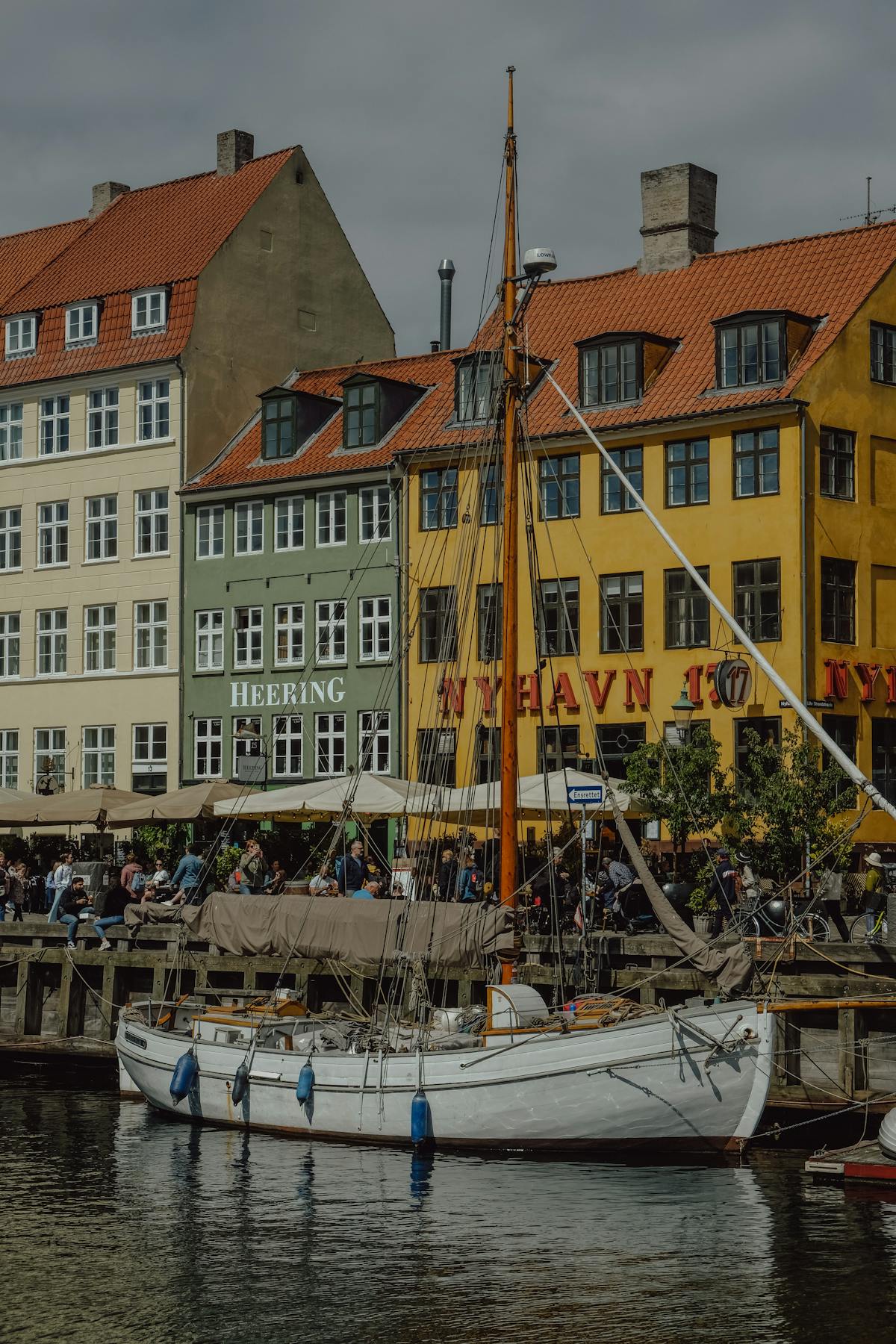 Vintage sailboat moored at Nyhavn canal with colourful Copenhagen buildings behind
