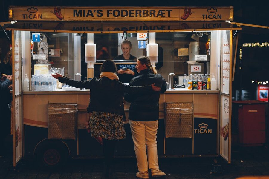Women buying food at a street stand at night in Copenhagen Denmark