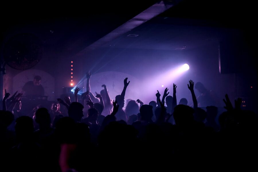 Crowd dancing in nightclub under spotlights