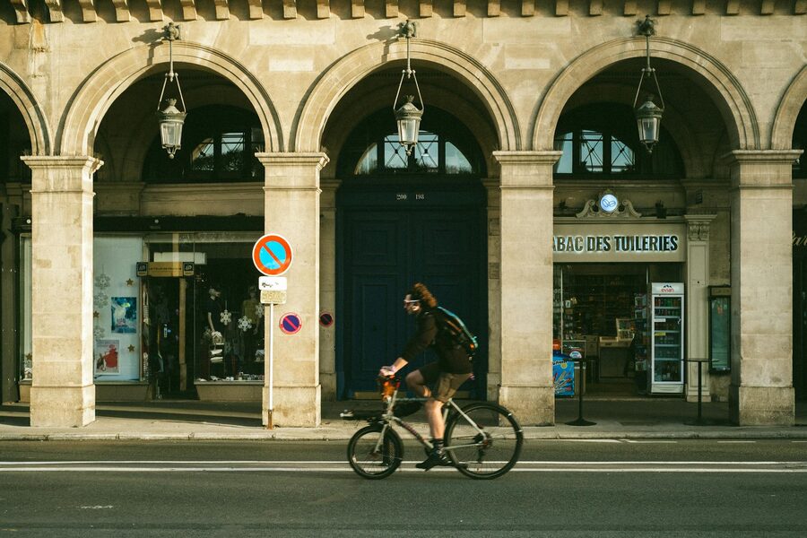 Cyclist riding under historic arches in Paris
