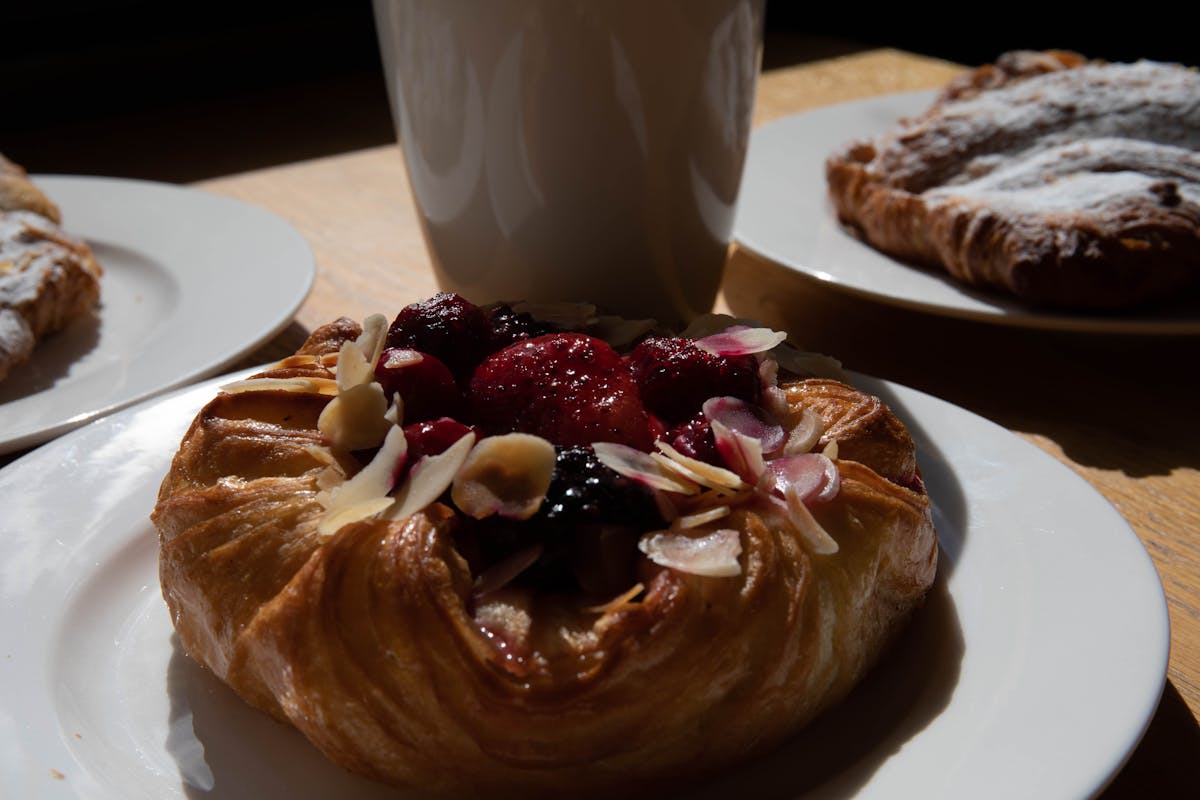 Danish pastry topped with berries and almonds on a sunny morning