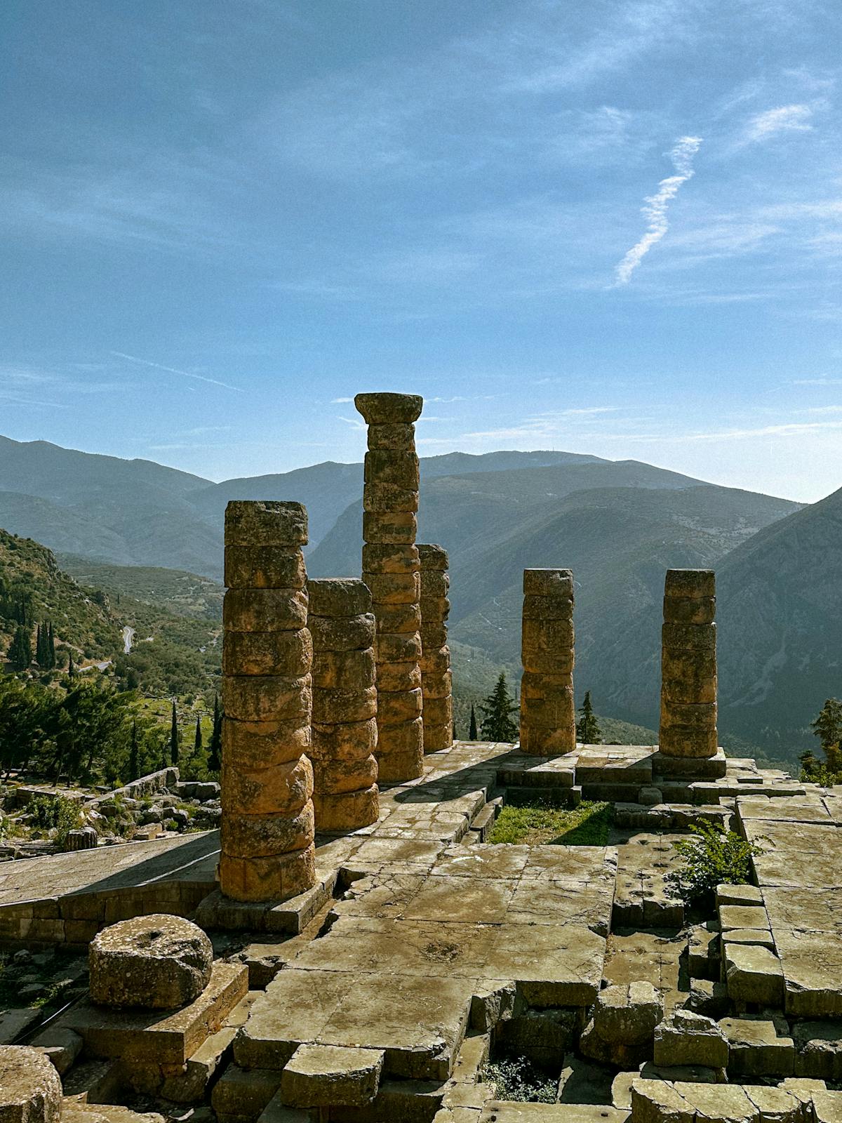 Temple of Apollo ruins in Delphi with mountain backdrop