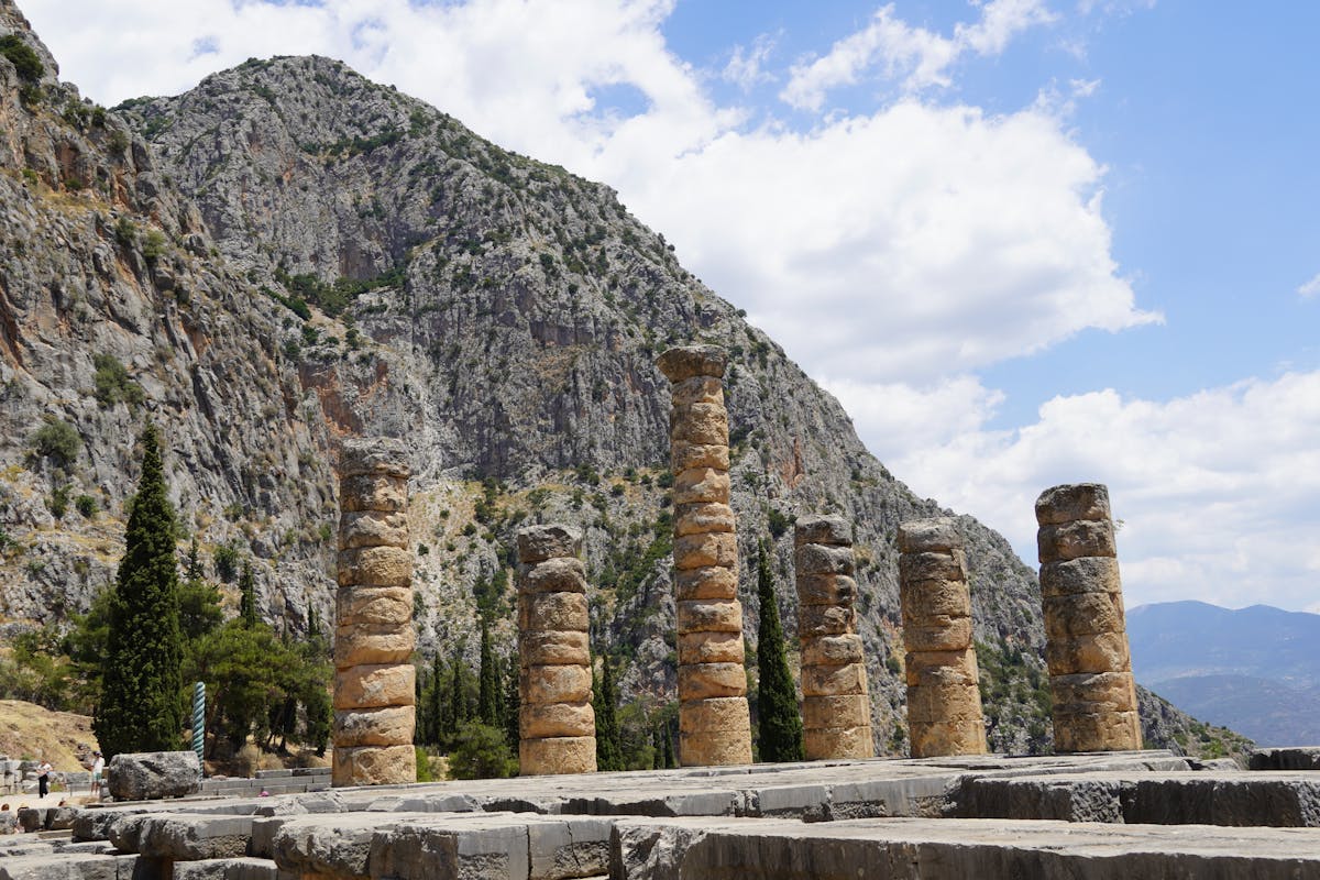 Ancient temple columns at Delphi under a bright sky