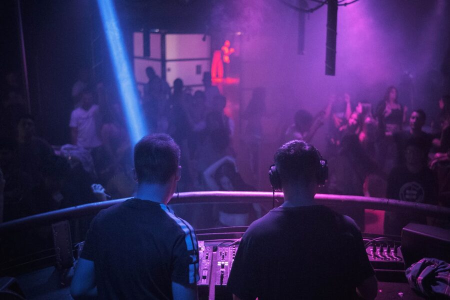 DJ mixing music in nightclub with lights