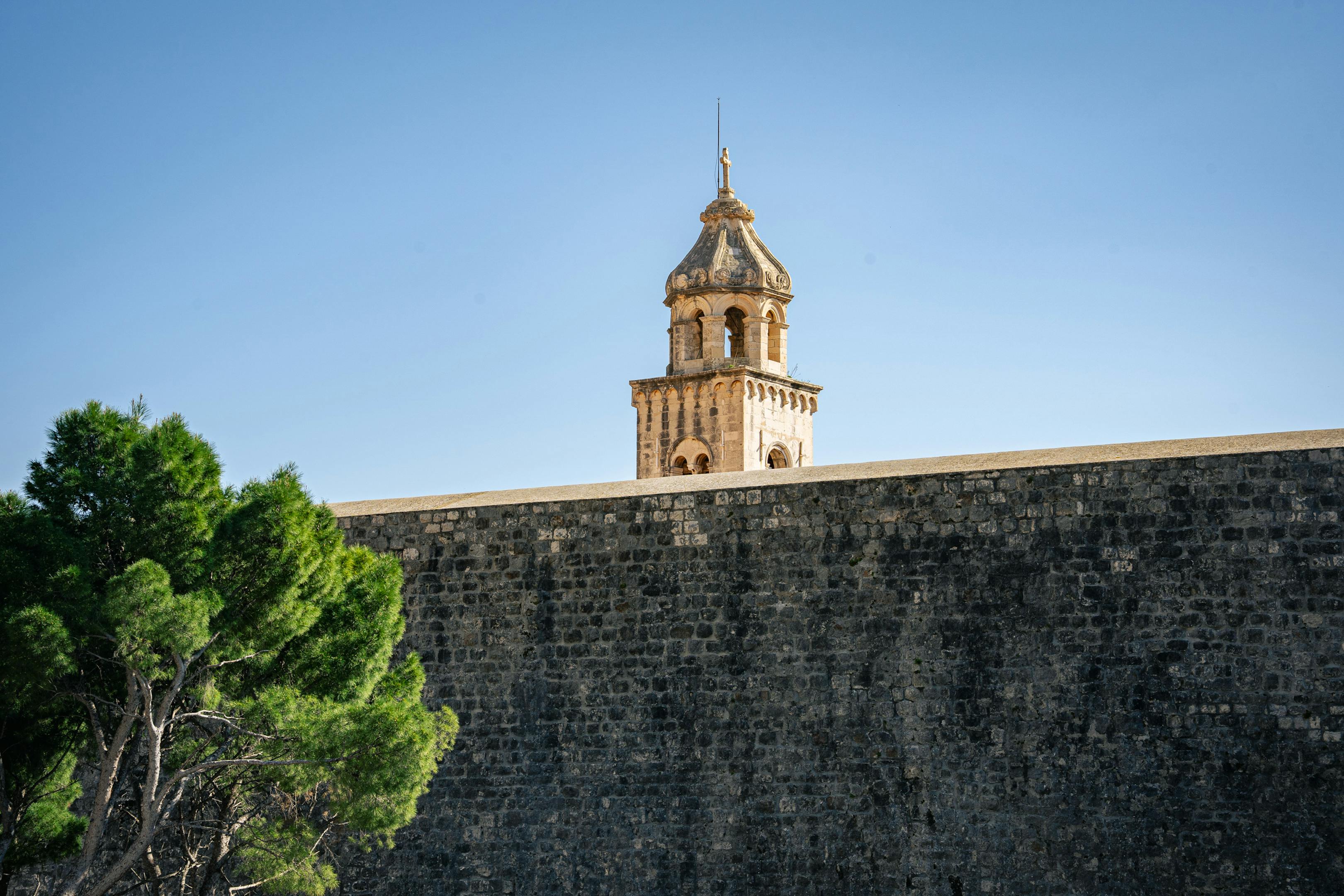 Capture of a historic bell tower rising above Dubrovnik's ancient stone walls in Croatia