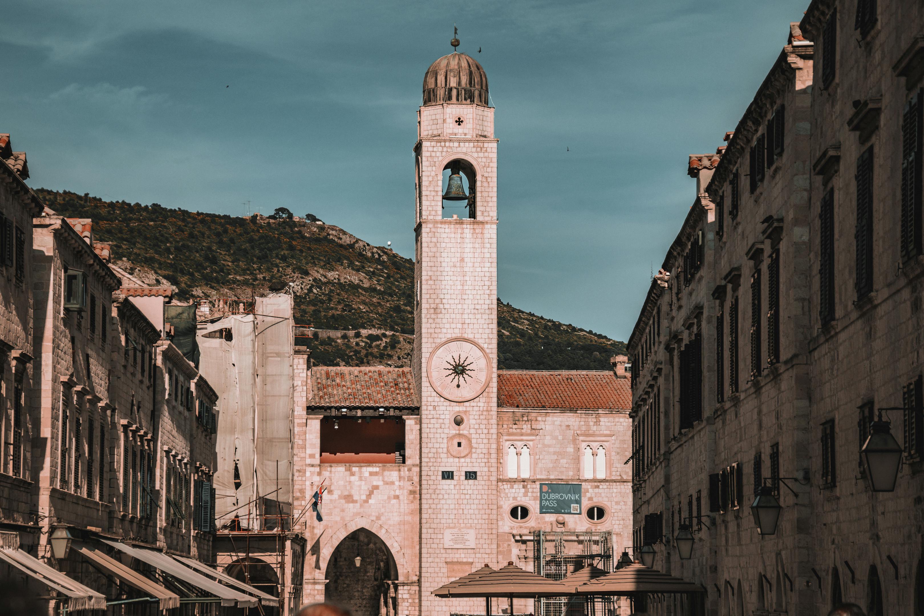 Explore Dubrovnik's iconic clock tower in the sunlit Old Town streets, Croatia