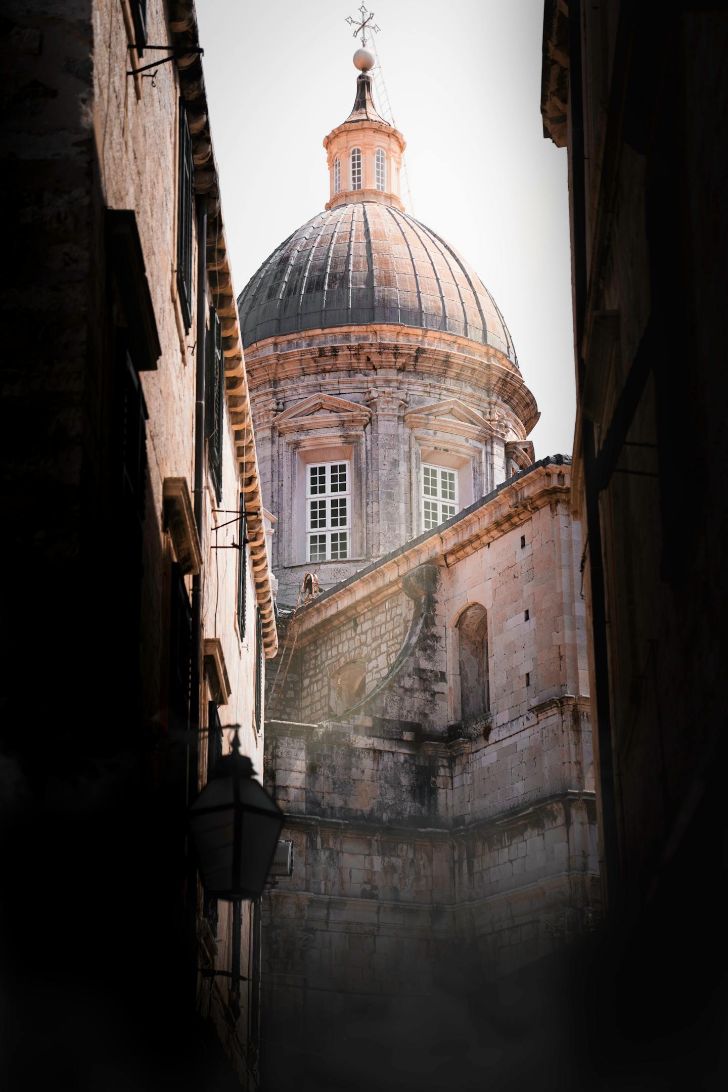 View of a historic dome through a narrow alley in Dubrovnik's Old Town