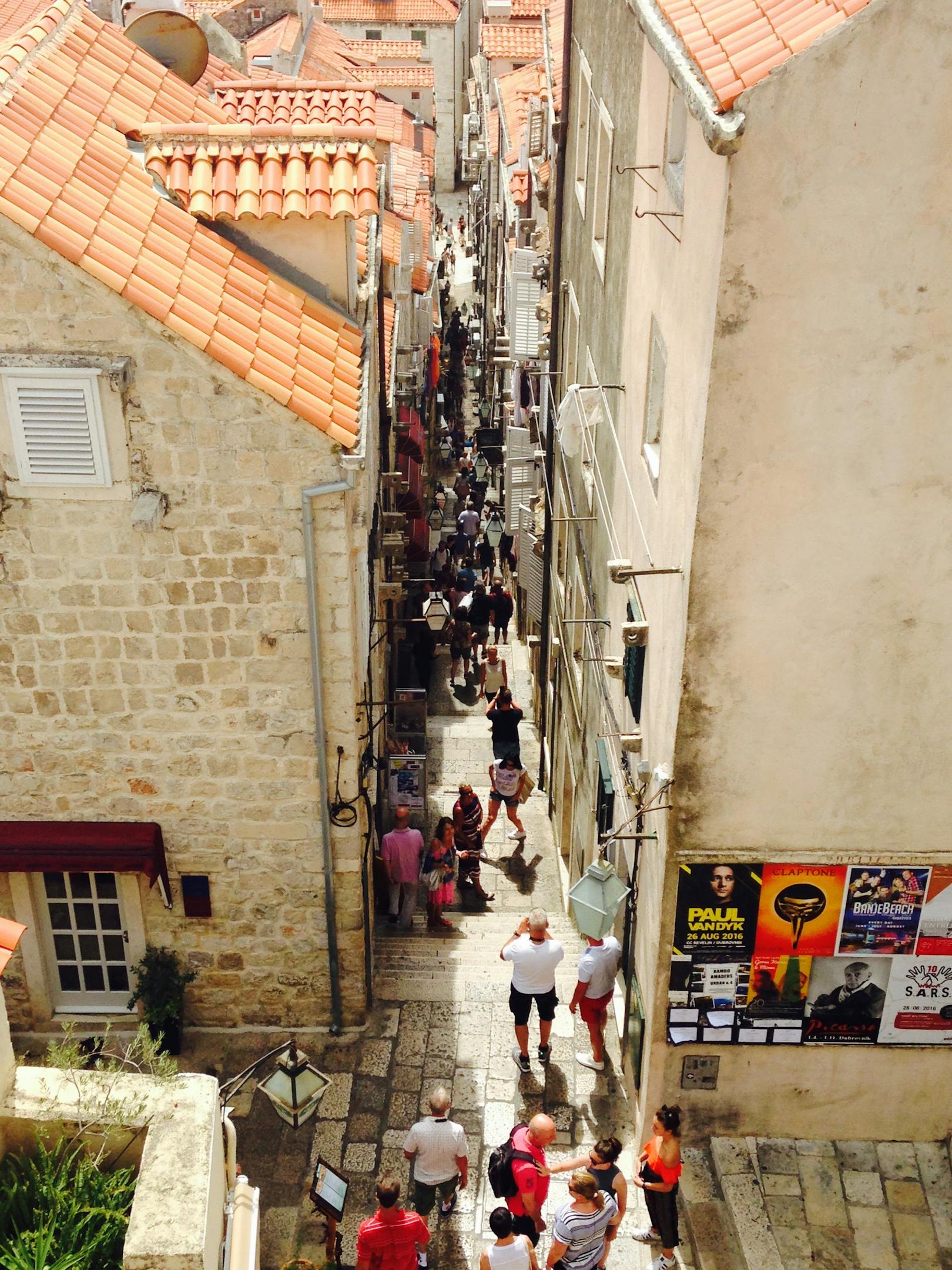 A vibrant narrow street in Dubrovnik Old Town showcasing historic stone architecture