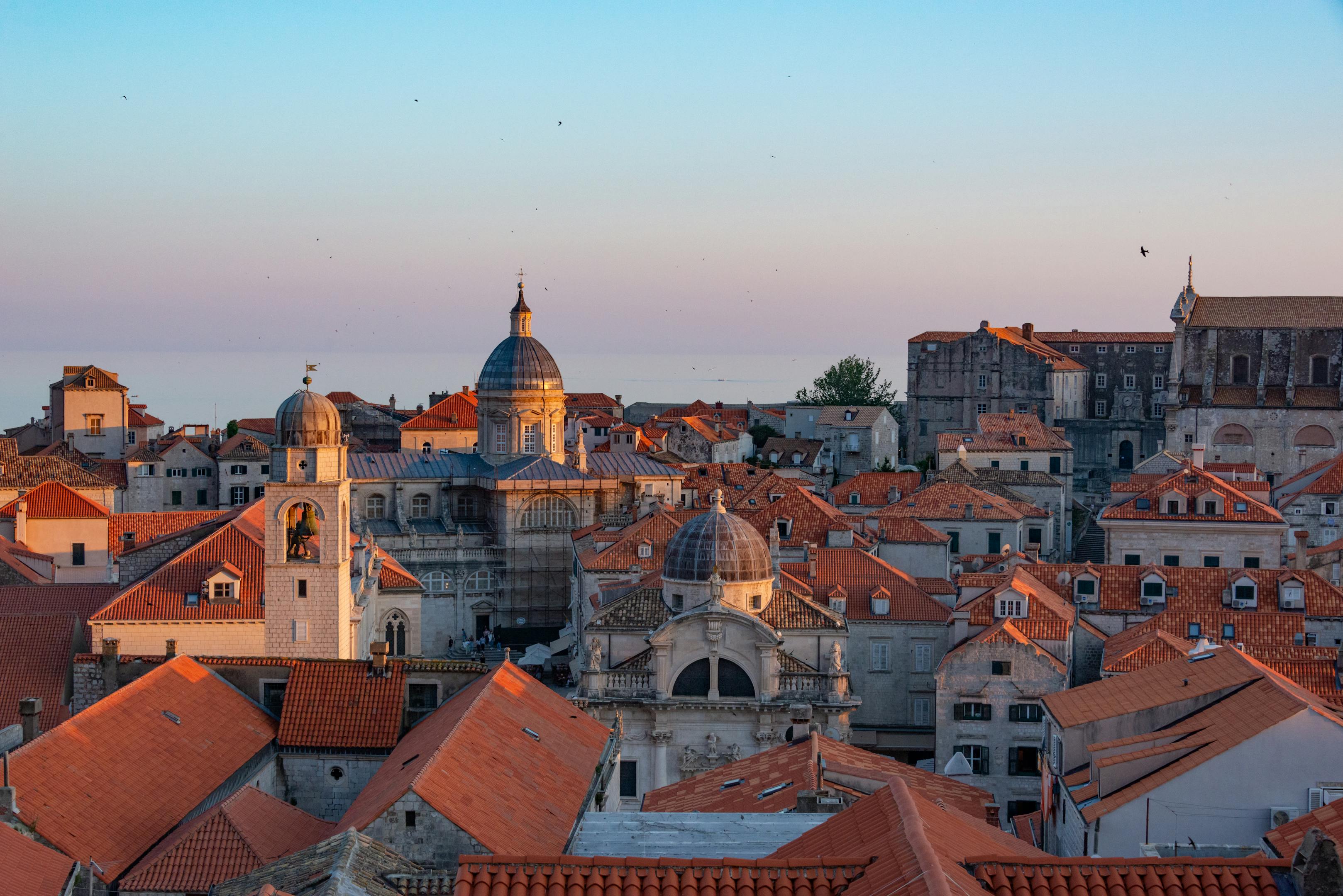 Aerial view of Dubrovnik's historic rooftops at sunset, showcasing Gothic architecture