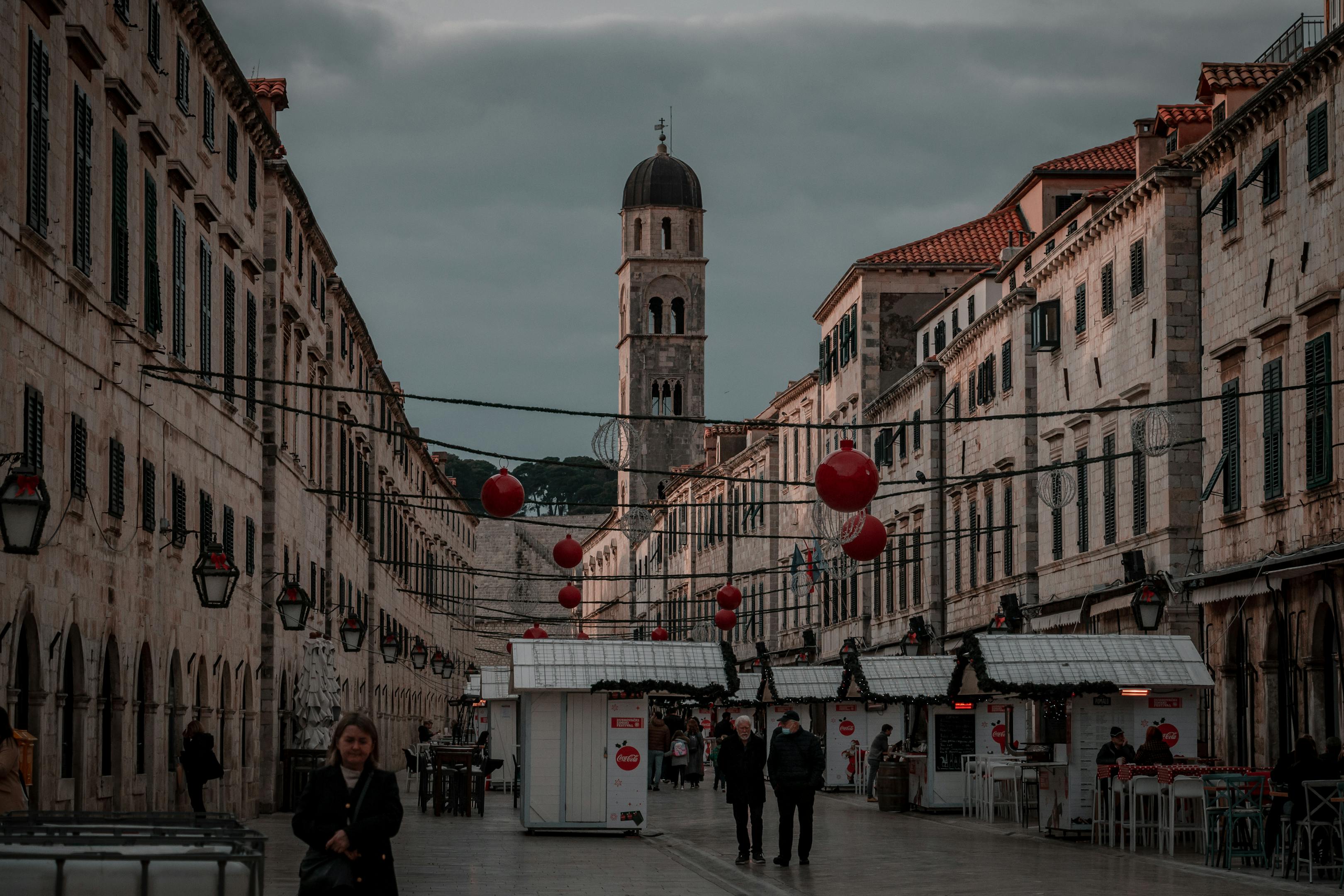 View of Stradun street with festive decorations in Dubrovnik, Croatia, featuring historic architecture and a prominent bell tower