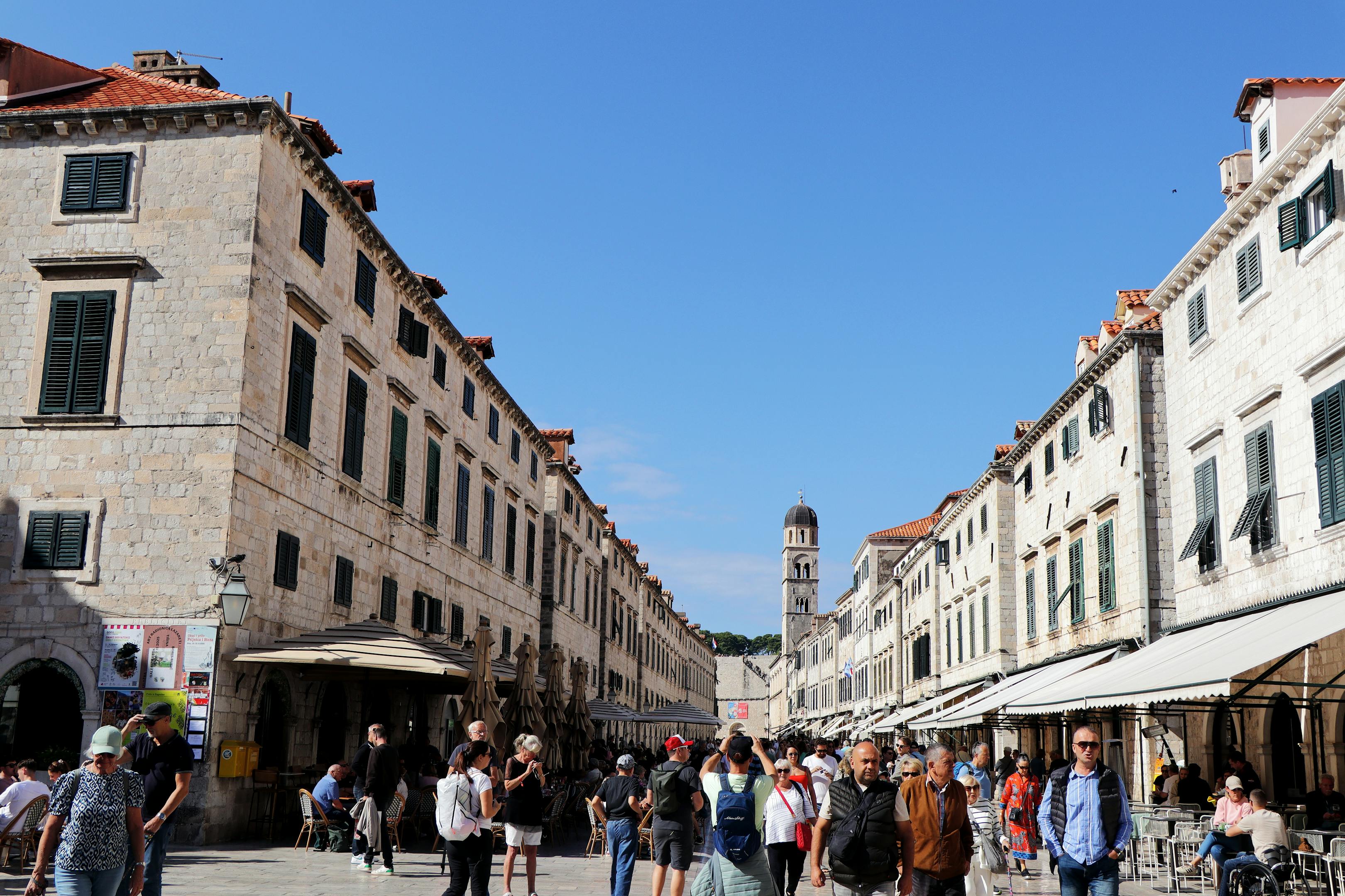 Explore the vibrant atmosphere of Dubrovnik's historic streets under a bright sunny sky