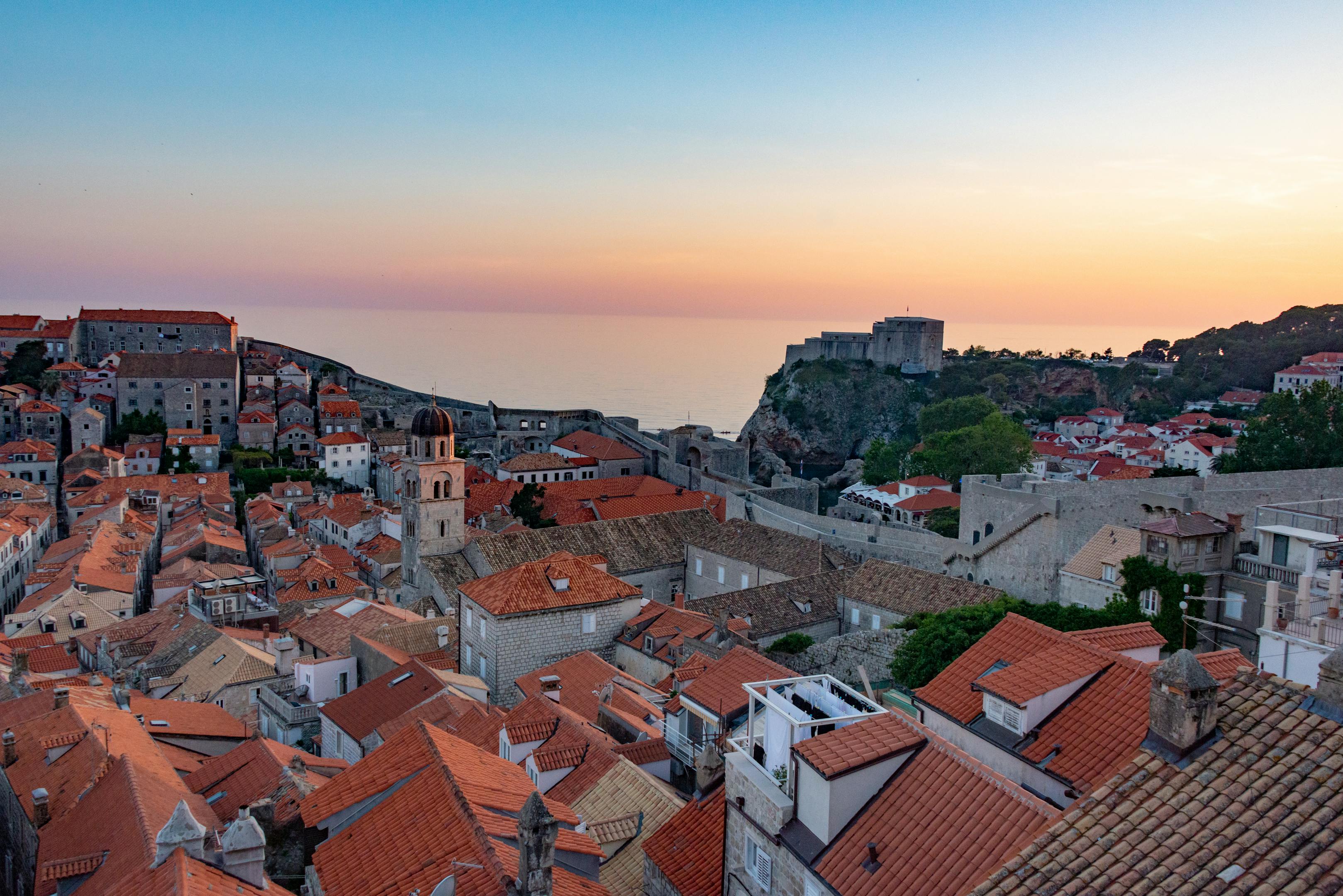 Scenic aerial view of Dubrovnik at sunset showcasing the historic cityscape and Adriatic Sea