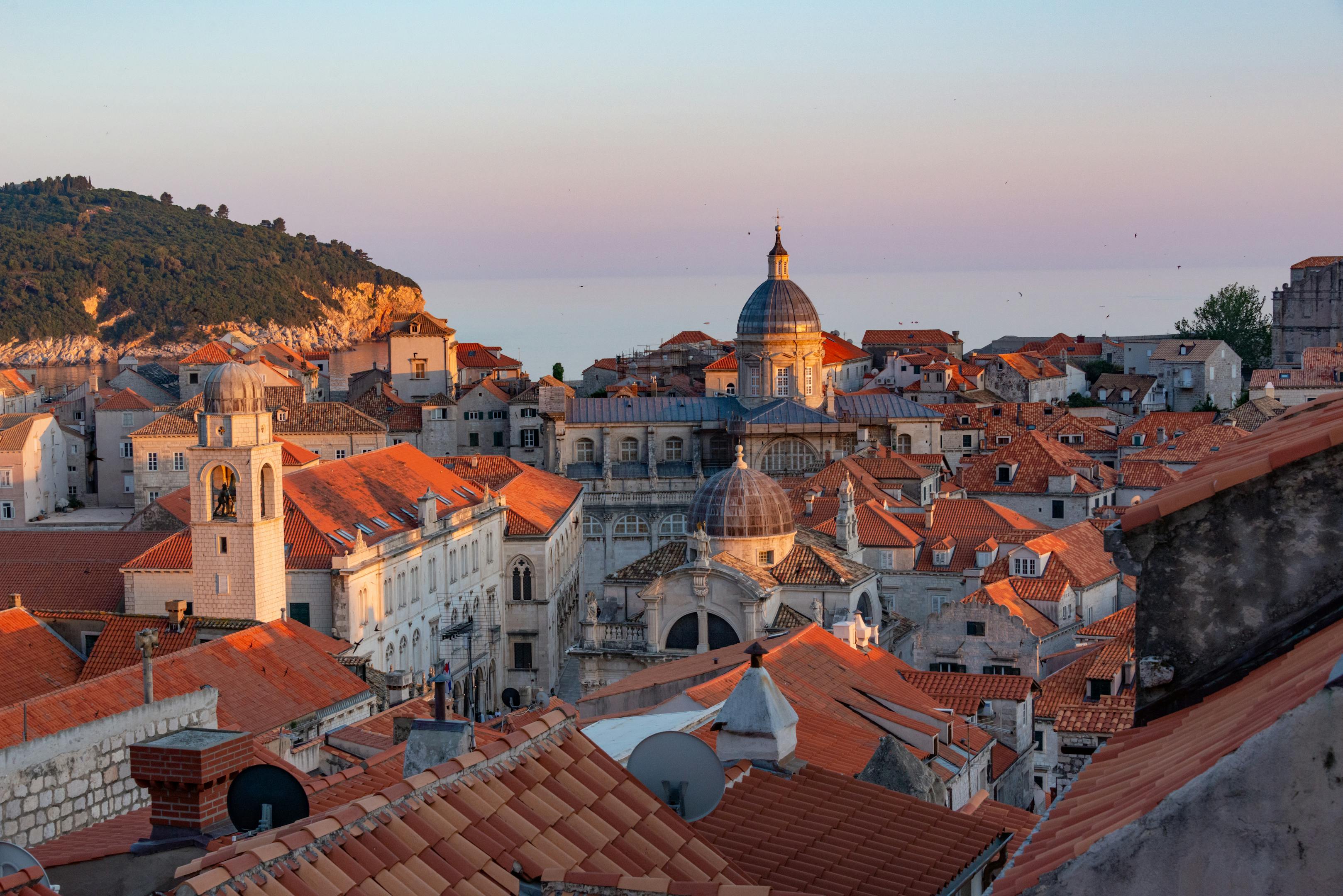 Dubrovnik's Old Town bathed in warm sunset light with terracotta rooftops glowing