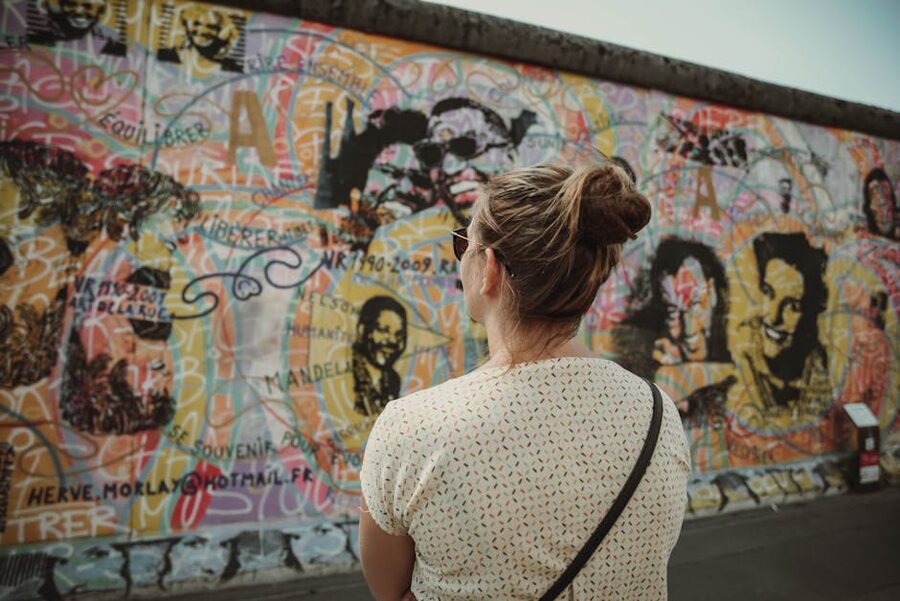 Visitor observing street art at the East Side Gallery Berlin Wall