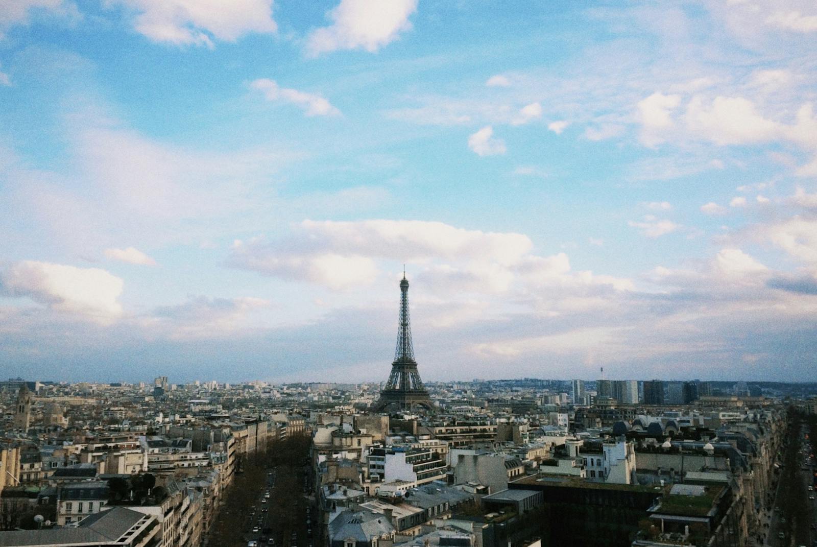 Aerial view of the Eiffel Tower rising above the Paris cityscape under a clear blue sky