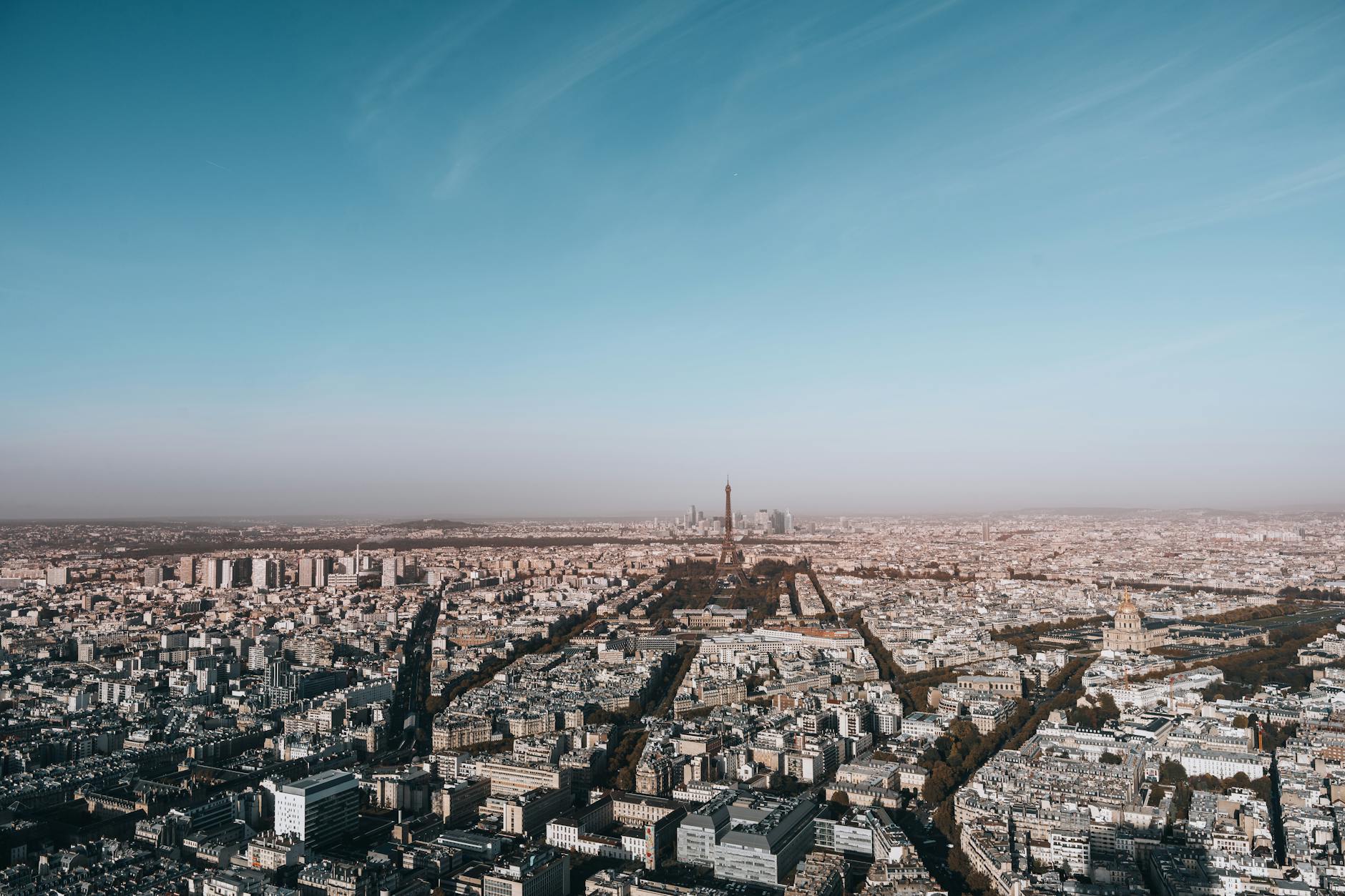Aerial view of the Eiffel Tower rising above Paris on a cloudy day