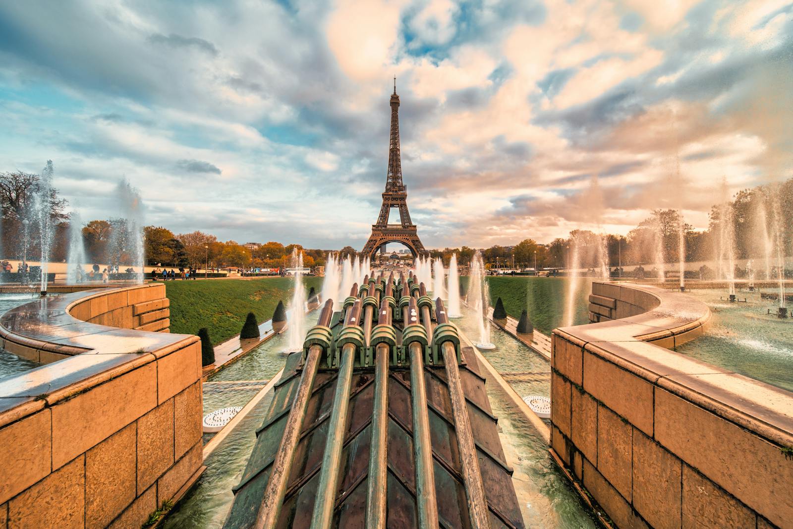 The Eiffel Tower at sunset with a fountain display in the foreground