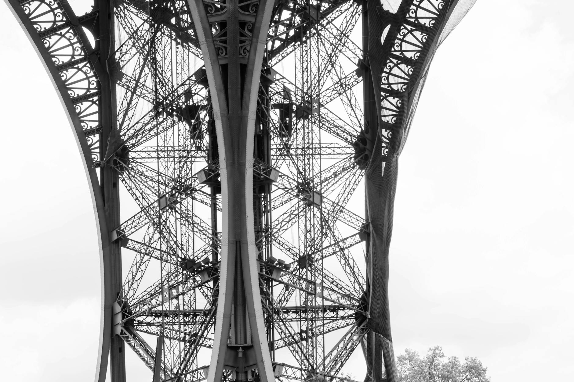 Close-up of the Eiffel Tower's riveted iron lattice showing the intricate crossbeam structure