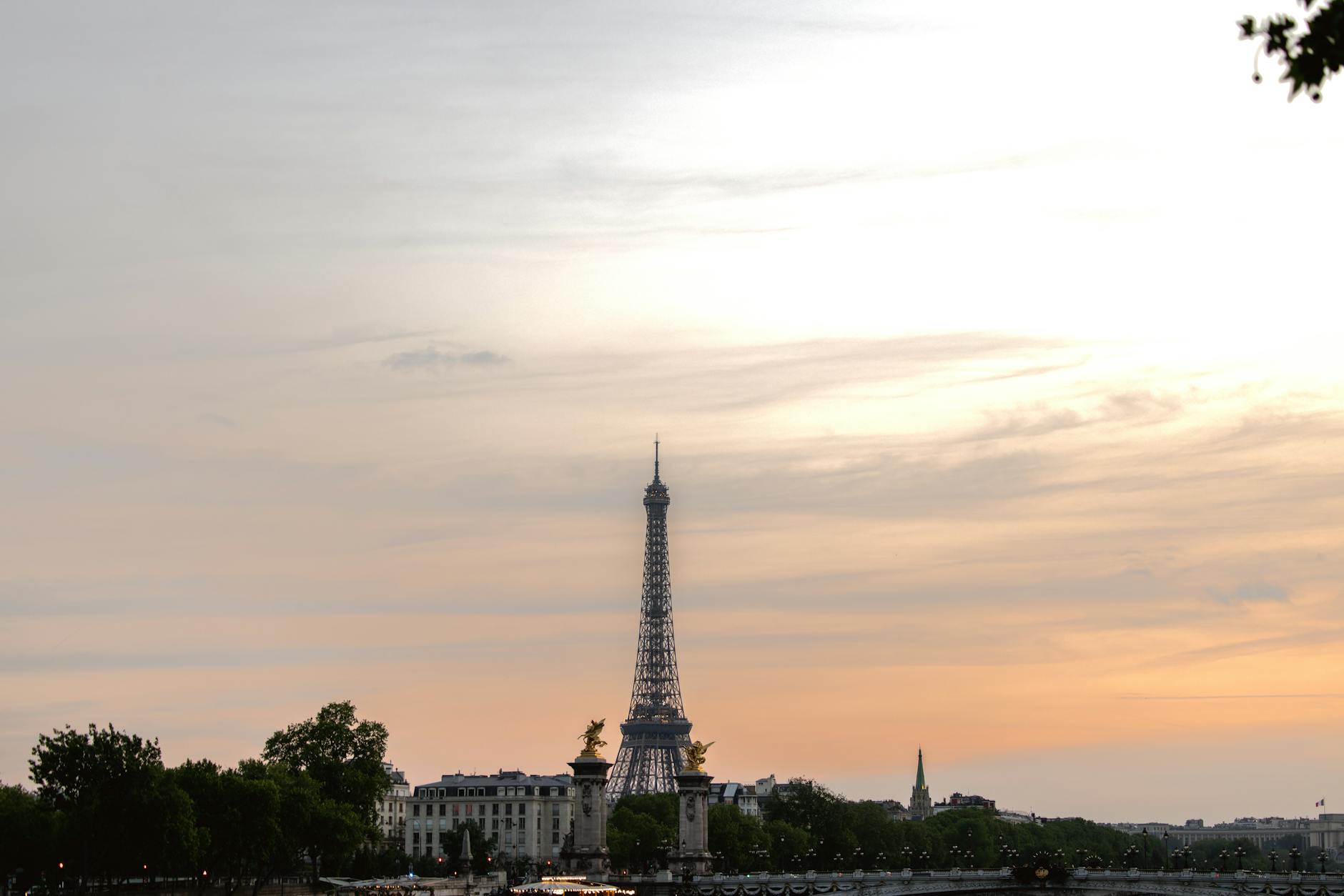 Eiffel Tower silhouetted against a golden sunset sky over Paris