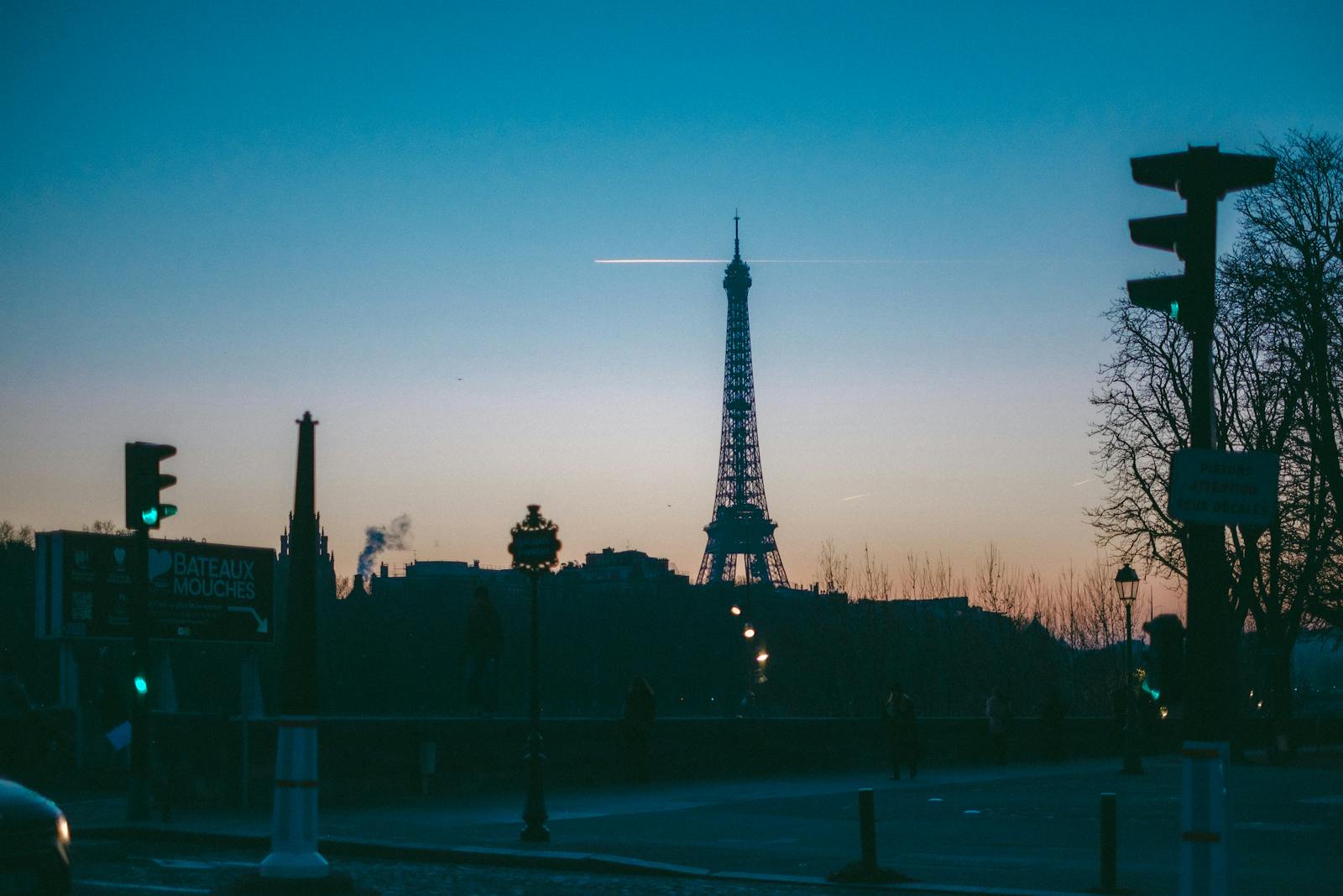 Silhouette of the Eiffel Tower at twilight framed by Paris city lights