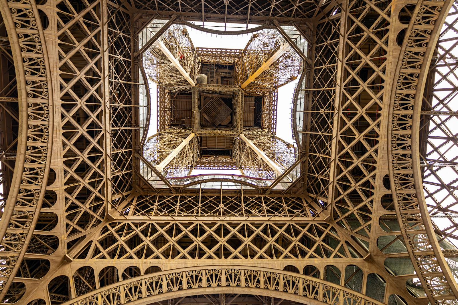 Under-view of the Eiffel Tower showcasing the intricate lattice design from directly beneath
