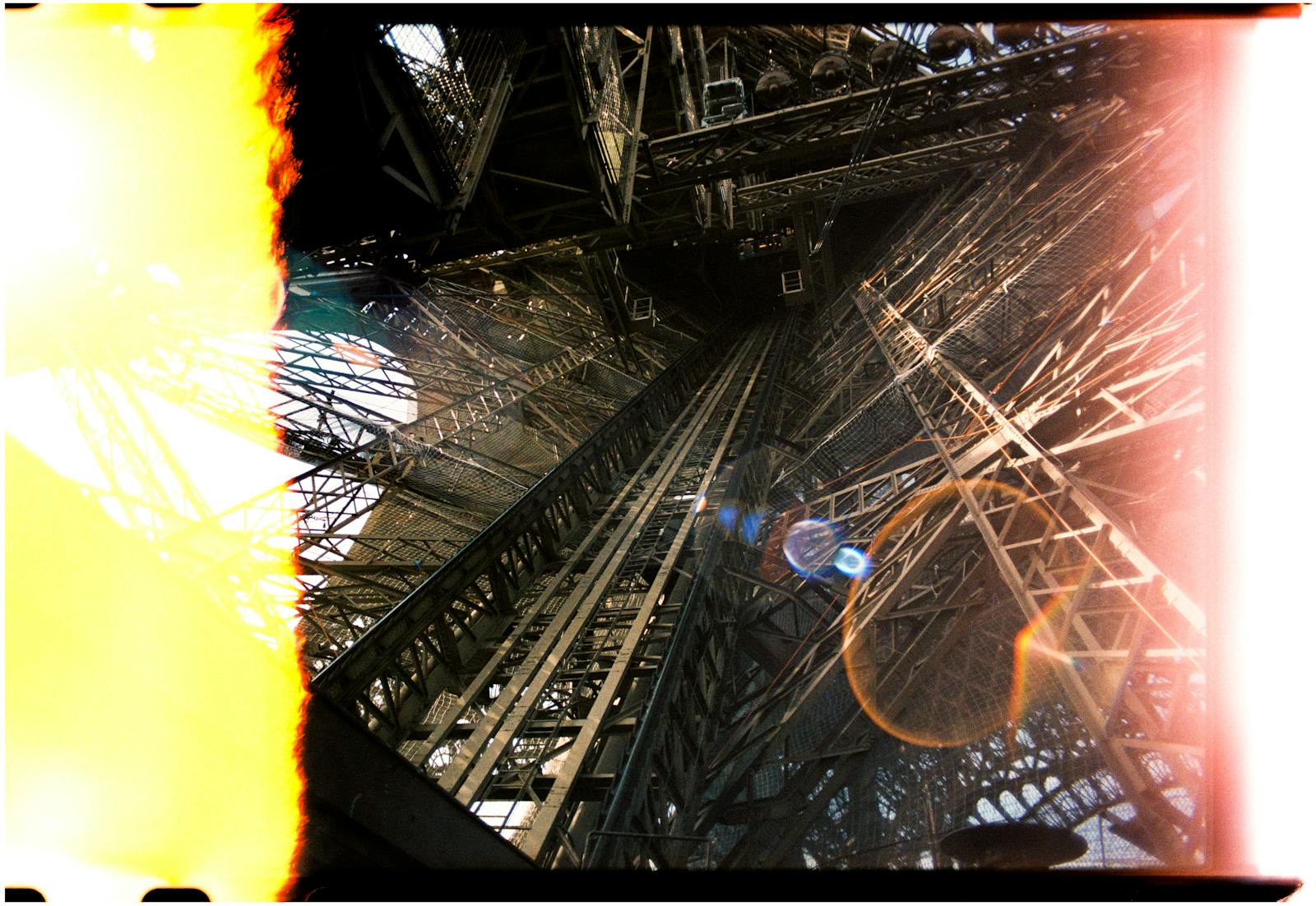 Dramatic upward view of the Eiffel Tower's interior framework and iron lattice