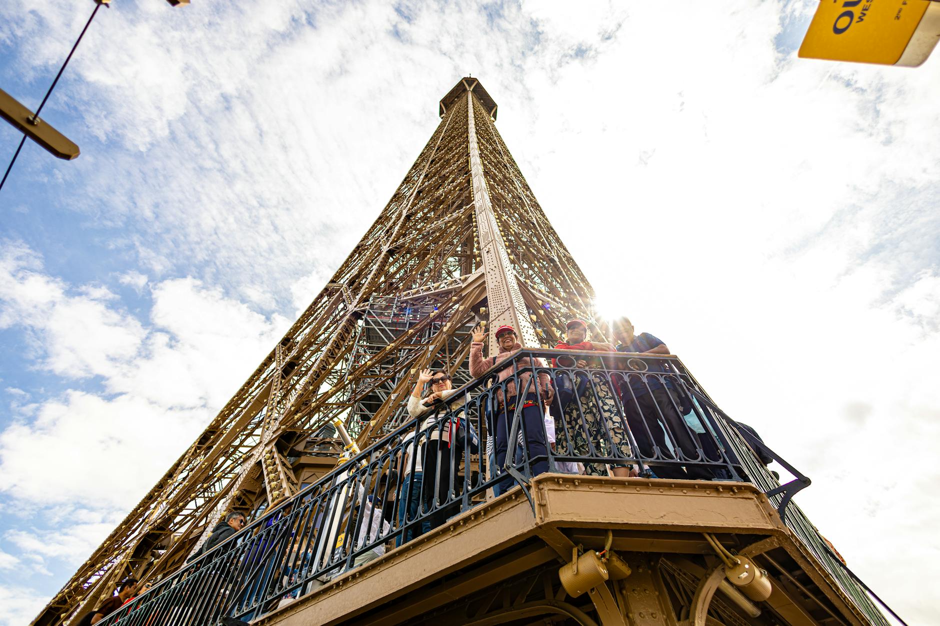 Eiffel Tower viewed from directly below with visitors walking between the four pillars