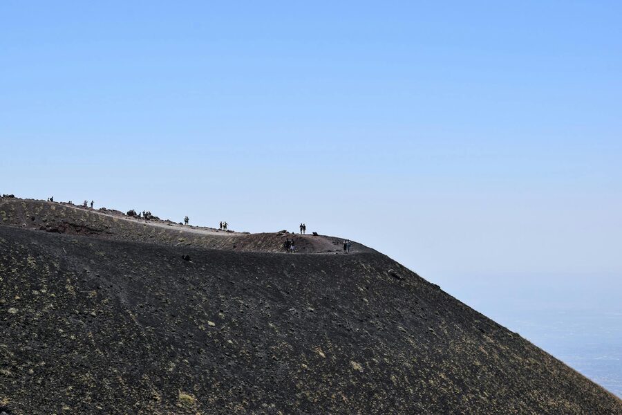 Hikers on Mount Etna rugged terrain
