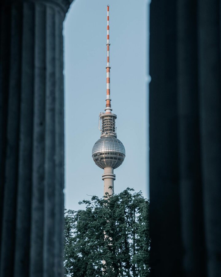 Berlin Fernsehturm seen through columns with a tree