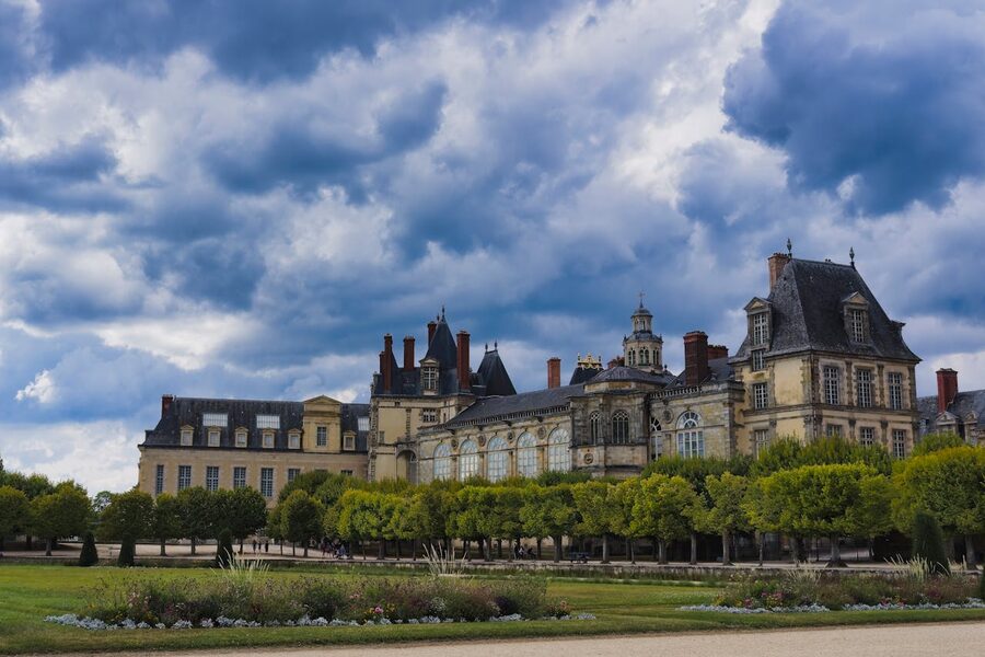 Fontainebleau Palace under a dramatic cloudy sky