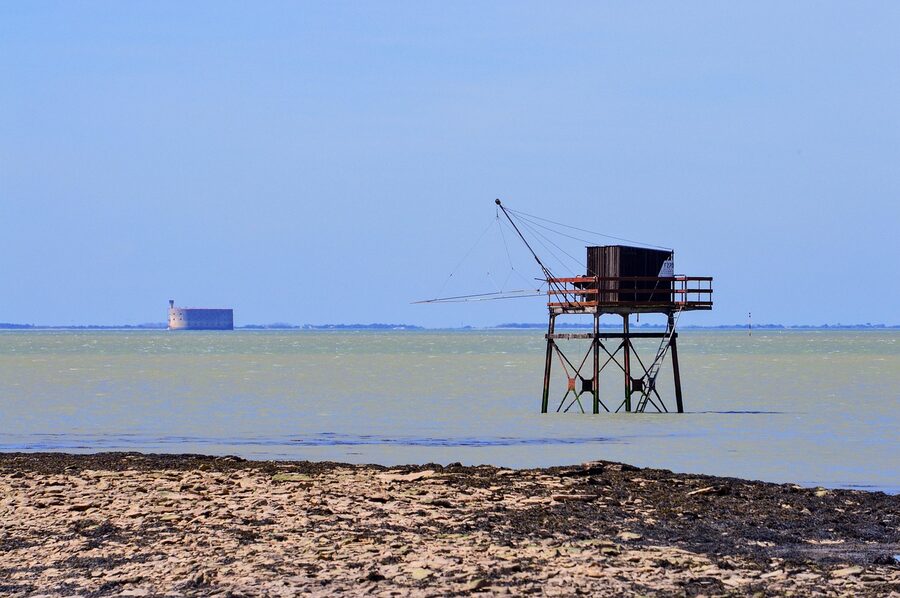 Fort Boyard in the distance with traditional fishing huts on the Charente coast