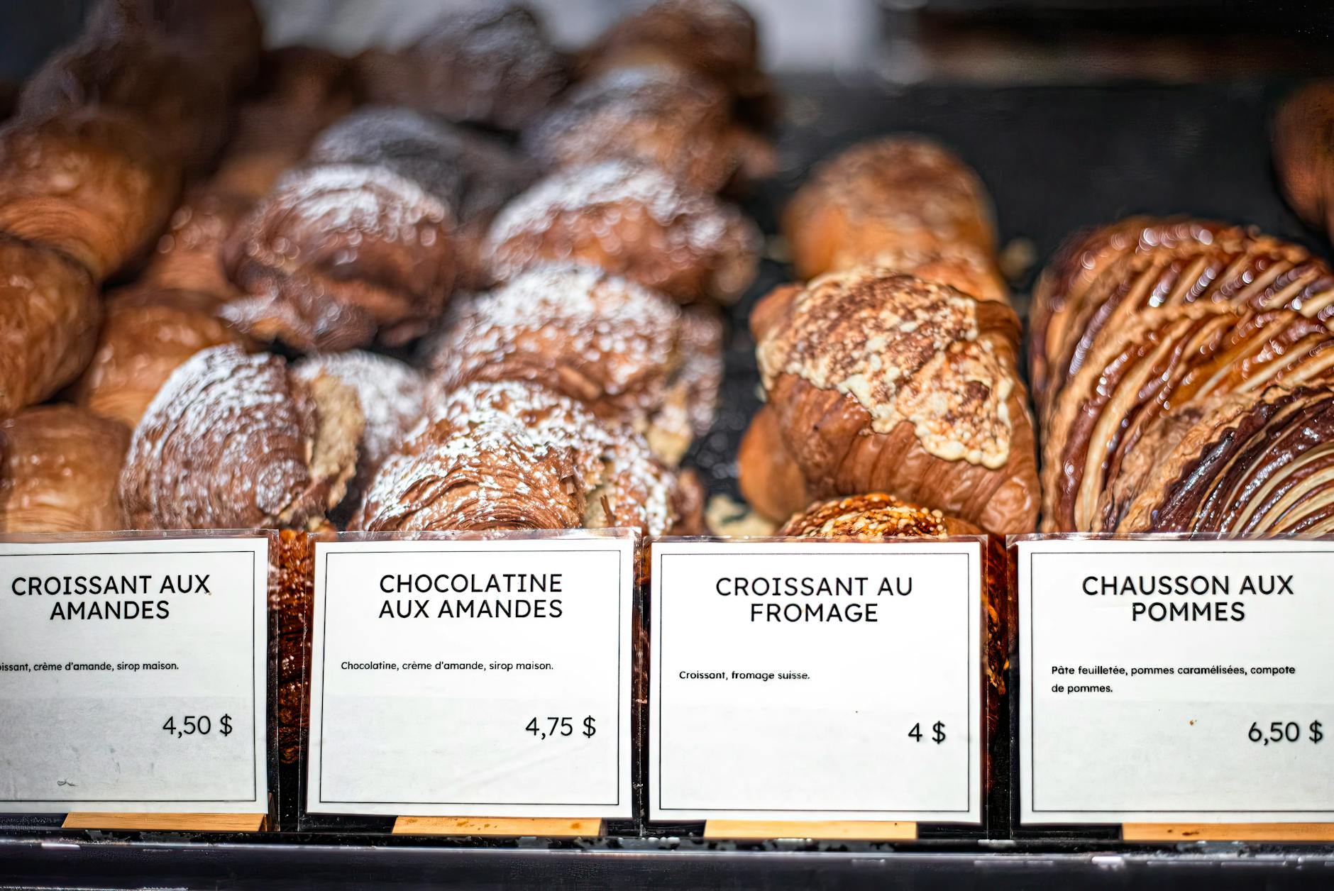 Delicious French pastries displayed with price tags at a bakery counter
