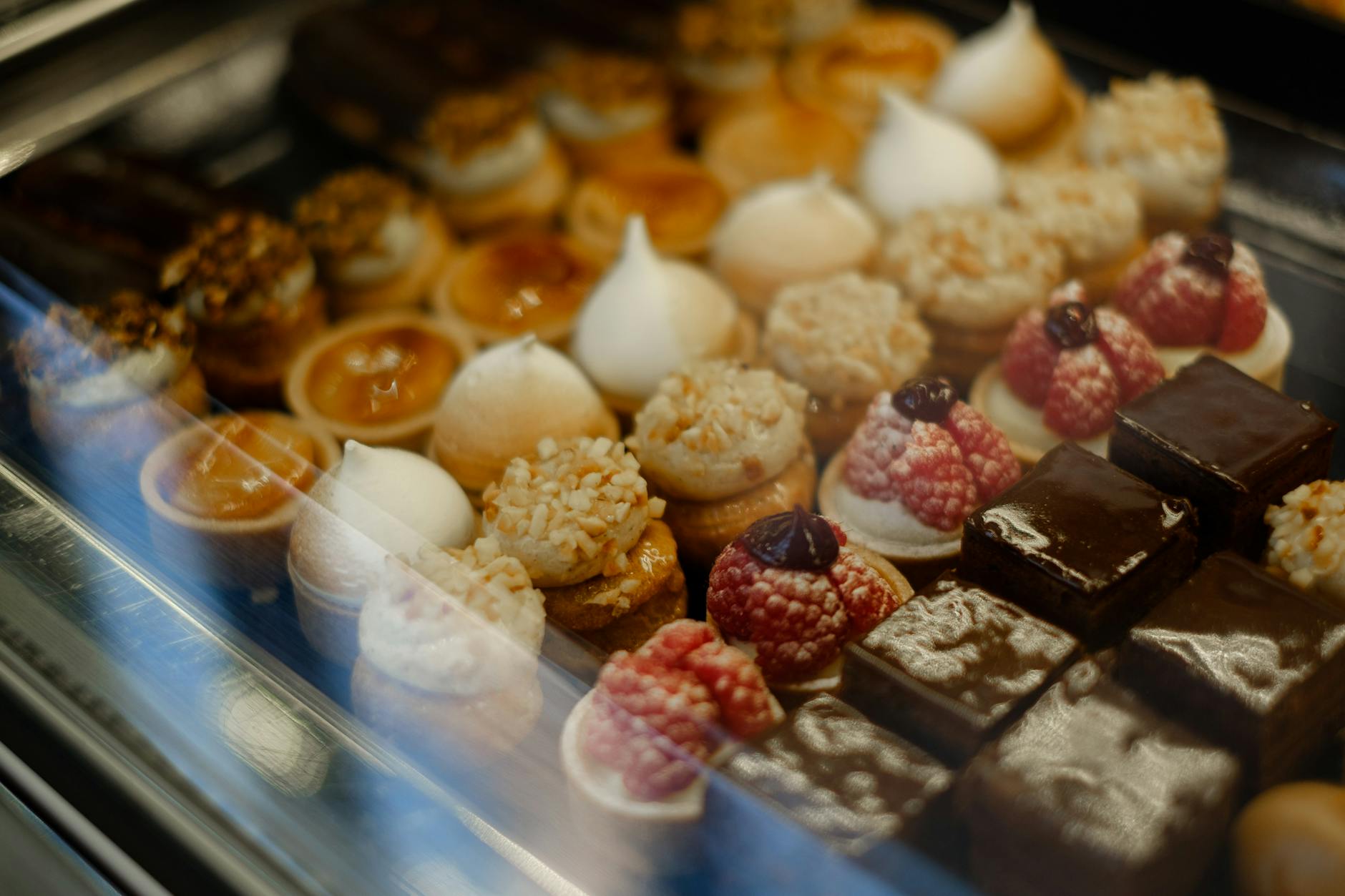 Assortment of French pastries tarts and chocolates displayed at a bakery counter