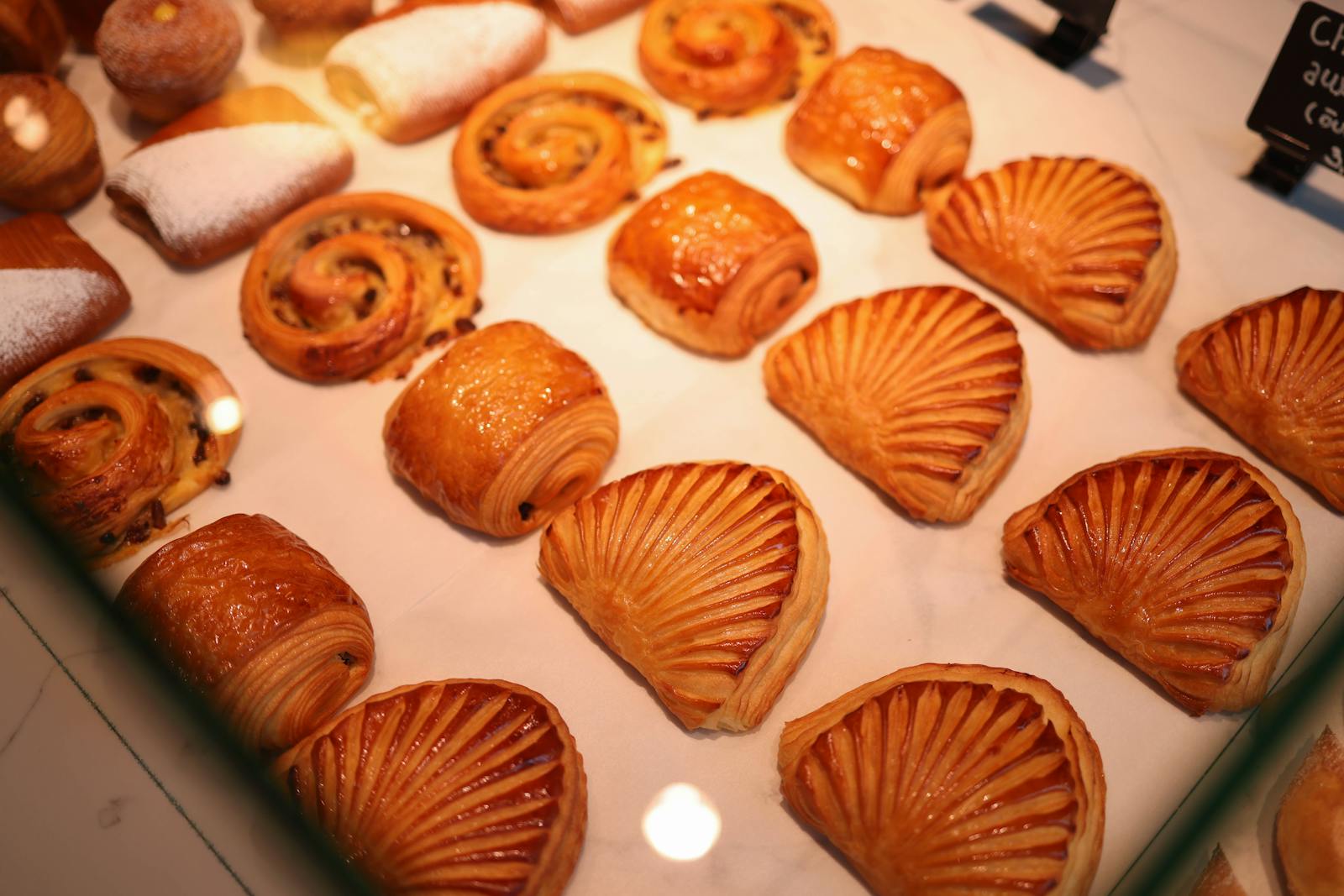 Assortment of freshly baked French pastries and viennoiserie on a bakery counter
